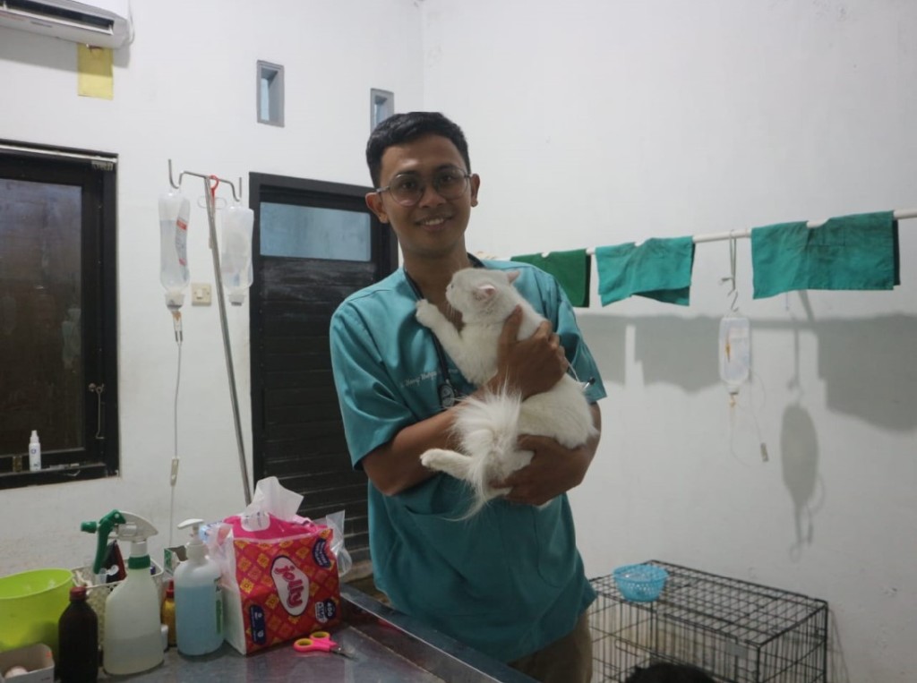 GENDONG: Drh Hanif Wahyu Wibisono pemilik WIBI Petshop and Patcare saat menggendong salah satu kucing yang dirawat di petshop miliknya.