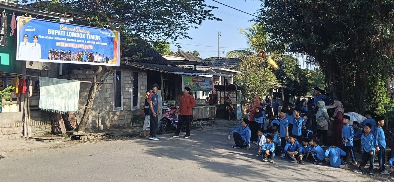 SAMBUT KEDATANGAN BUPATI: Siswa SDN 3 Batu Putik berjejer melihat spanduk selamat datang untuk Bupati Lombok Timur di Kecamatan Keruak, beberapa waktu lalu.