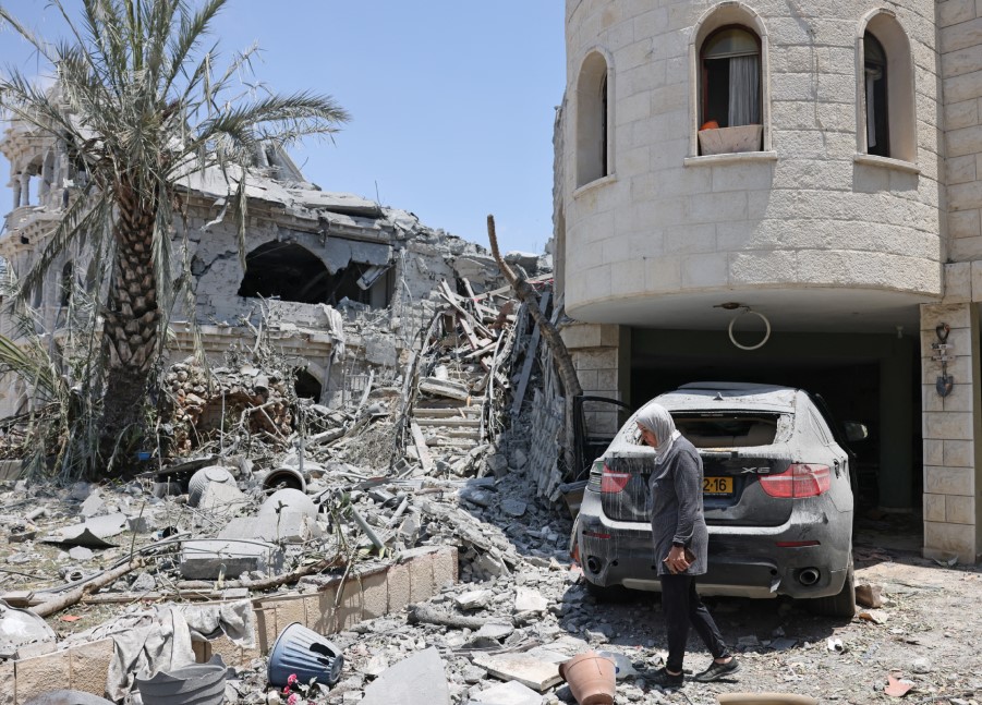 SERANGAN BALASAN: Seorang perempuan memeriksa kerusakan sebuah rumah di Kota Tamra, Israel, kemarin (17/6). Kerusakan ini diakibatkan oleh rudal Iran balasan serangan Israel. AHMAD GHARABLI / AFP