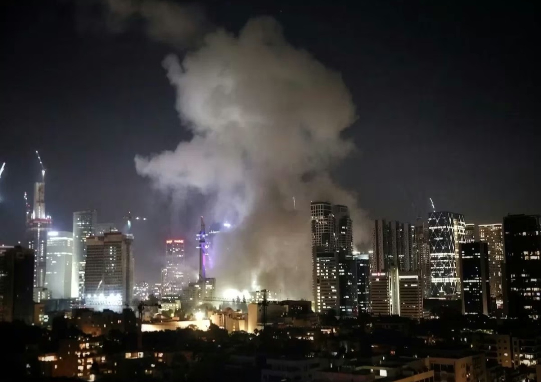 Asap tebal membubung setelah serangan rudal balasan dari Iran menghantam wilayah Tel Aviv, Israel, pada Jumat malam, 13 Juni 2025.