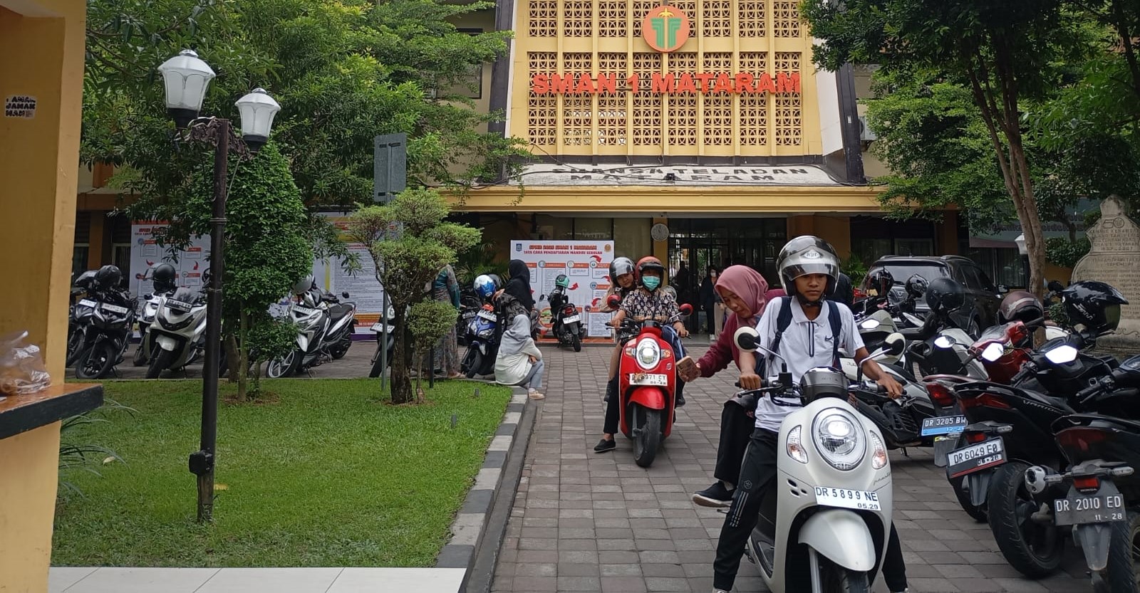 Calon siswa bersama orang tuanya pulang usai daftar SPMB jalur prestasi di SMAN 1 Mataram, Jumat (20/6).