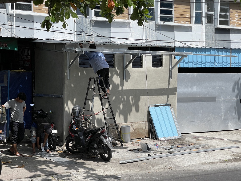 LANGGAR ATURAN: Pekerja terlihat masih melanjutkan pembangunan dapur makan bergizi gratis di kawasan Sayang-Sayang, Mataram, meski bangunan ini dinilai melanggar aturan tata ruang.