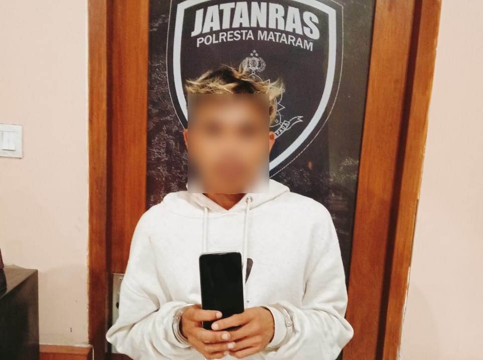 DITANGKAP: Tersangka pencurian TA alias Toni menunjukkan handphone yang sudah dicurinya, Minggu (22/6).