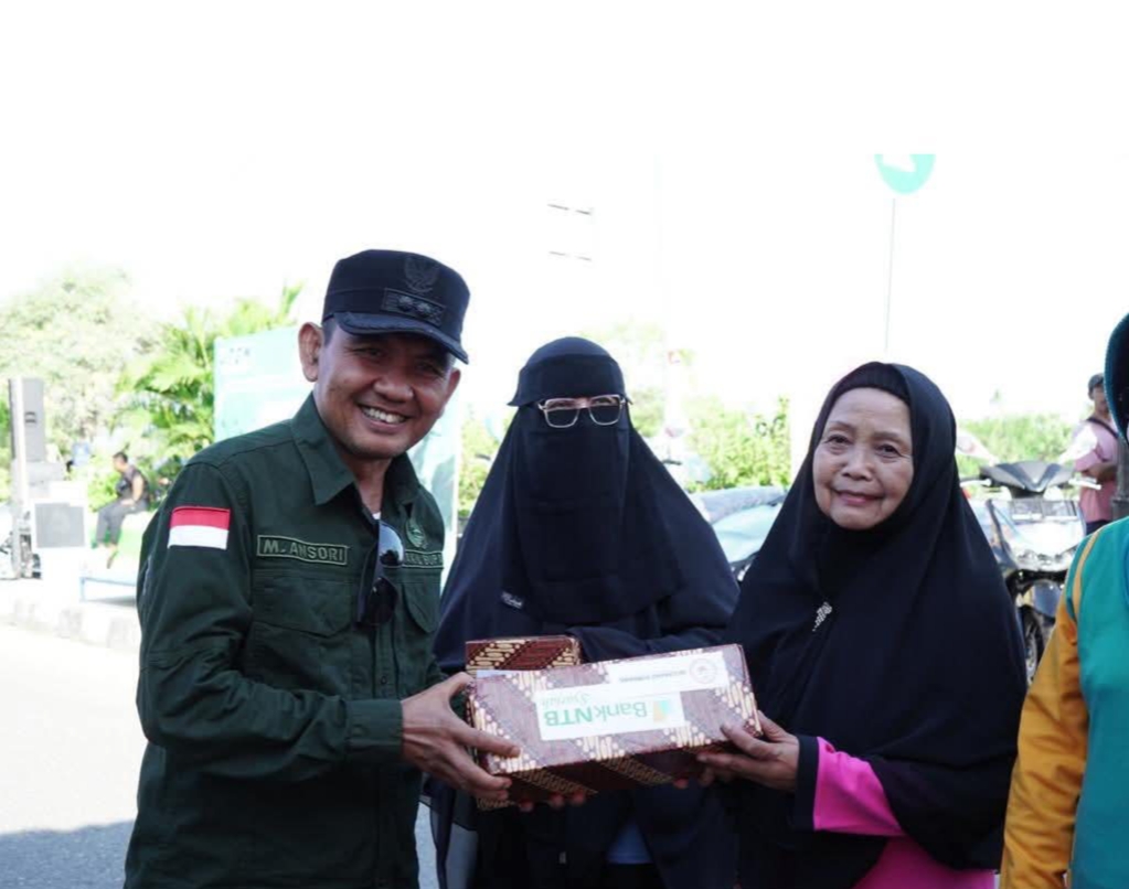 Wabup Sumbawa Mohamad Ansori menyerahkan bingkisan kepada seorang bidan saat menghadiri peringatan Hari Bidan Sedunia dan IBI ke-74 di Samota, Minggu (22/6).