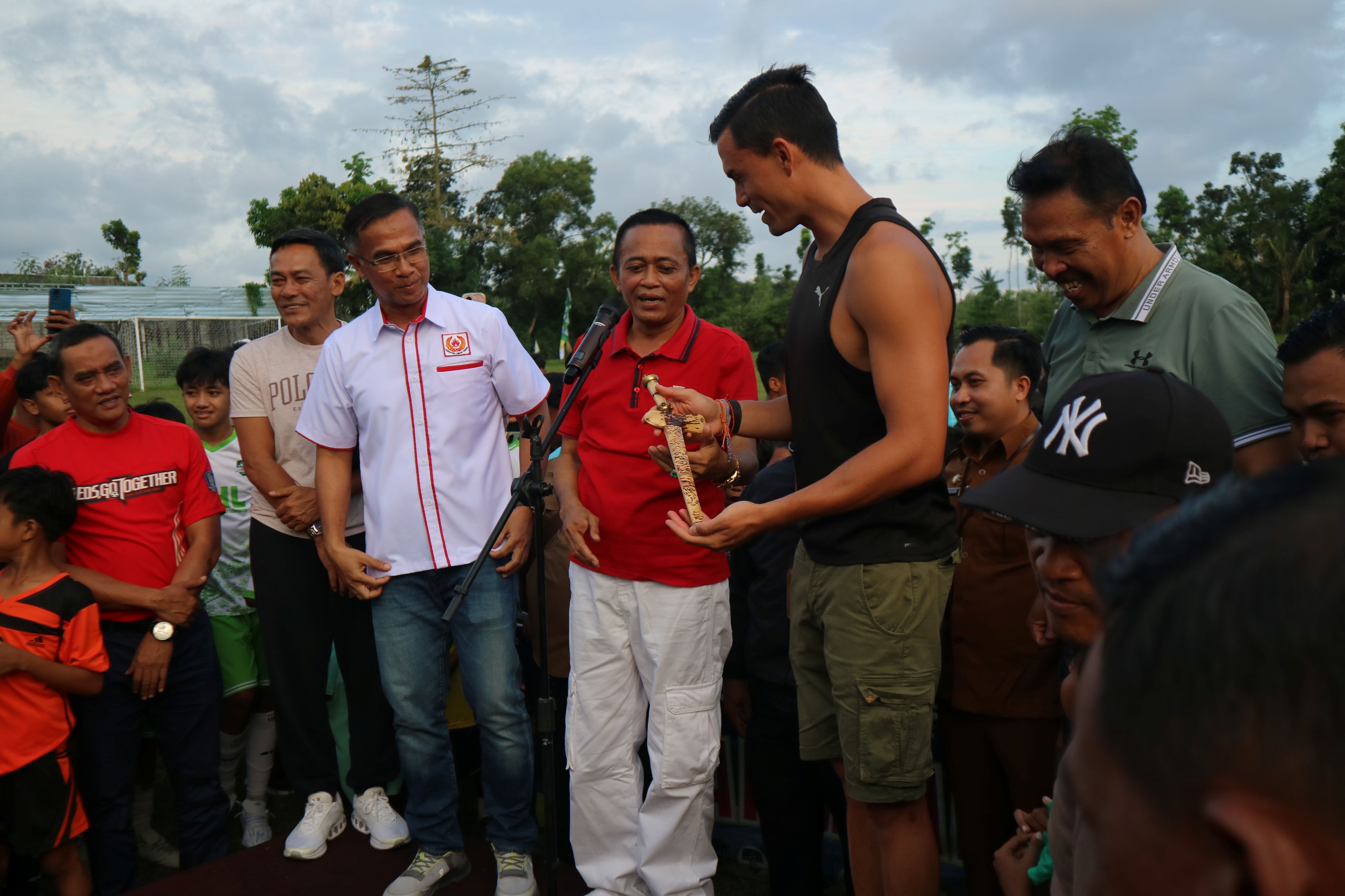 Emil Audero Mulyadi (kaos oblong) pemain timnas Indonesia menerima keris sebagai cinderamata dari Ketua Umum KONI Loteng HL Firman Wijaya di Lapangan Jontlak, Praya Tengah, Selasa (24/6).