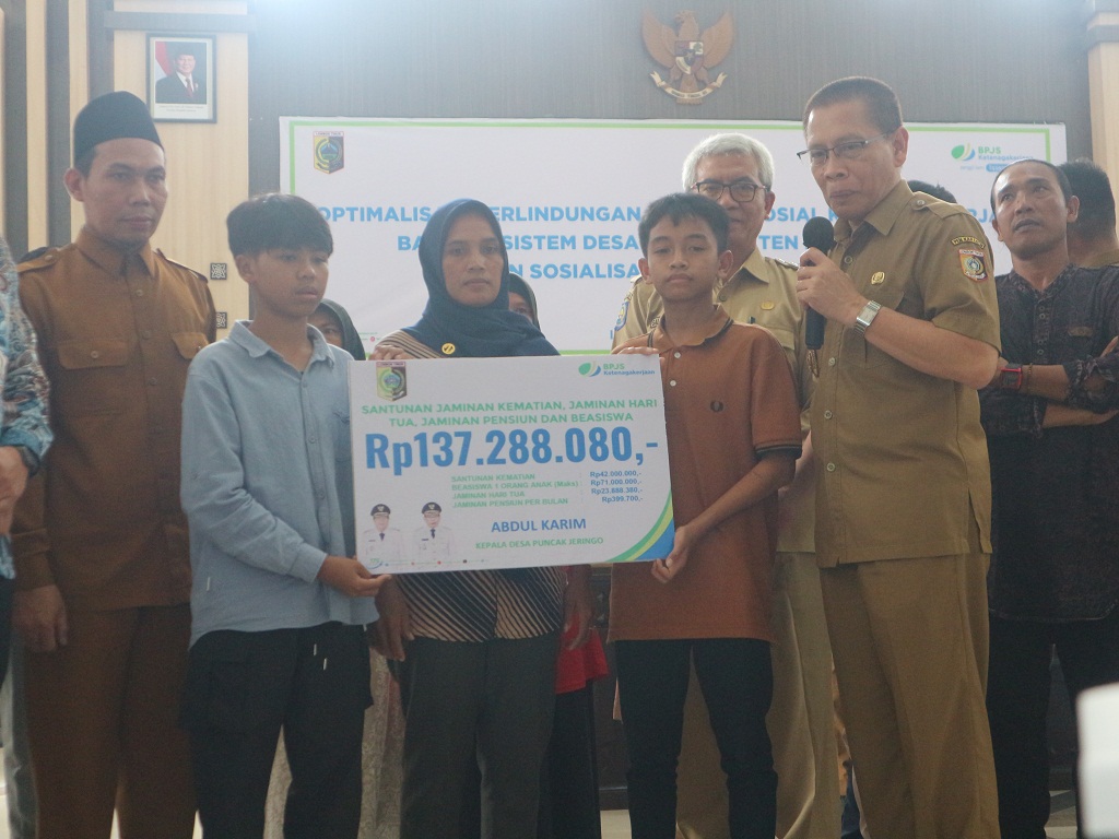 SERAHKAN: Wakil Bupati Lombok Timur (Lotim) H Moh Edwin Hadiwijaya saat memberikan santunan jaminan sosial kepada salah seorang ahli waris peserta BPJS Ketenagakerjaan yang meninggal dunia.