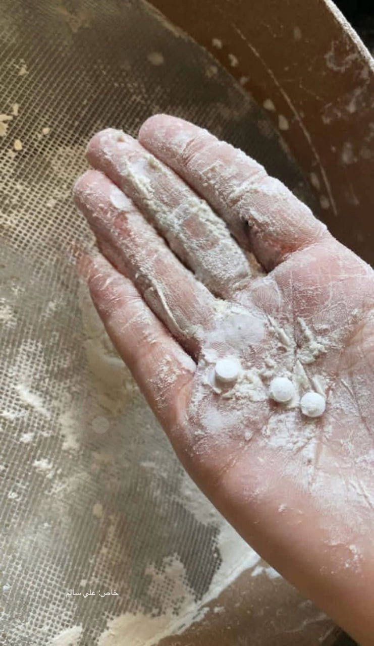 Petugas medis Gaza menunjukkan sampel tepung bantuan yang tercemar pil opioid hancur. (AFP via Getty Images)