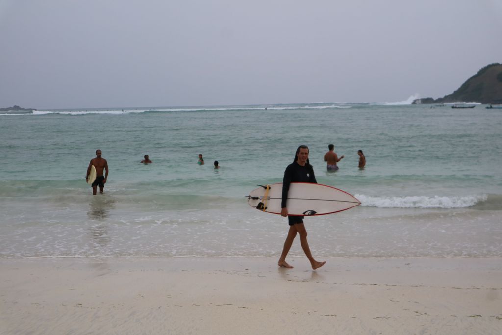 BERLIBUR: Sejumlah wisatawan asing usai berselancar di sekitar Pantai Tanjung Aan, Desa Sengkol, Pujut, Lombok Tengah.