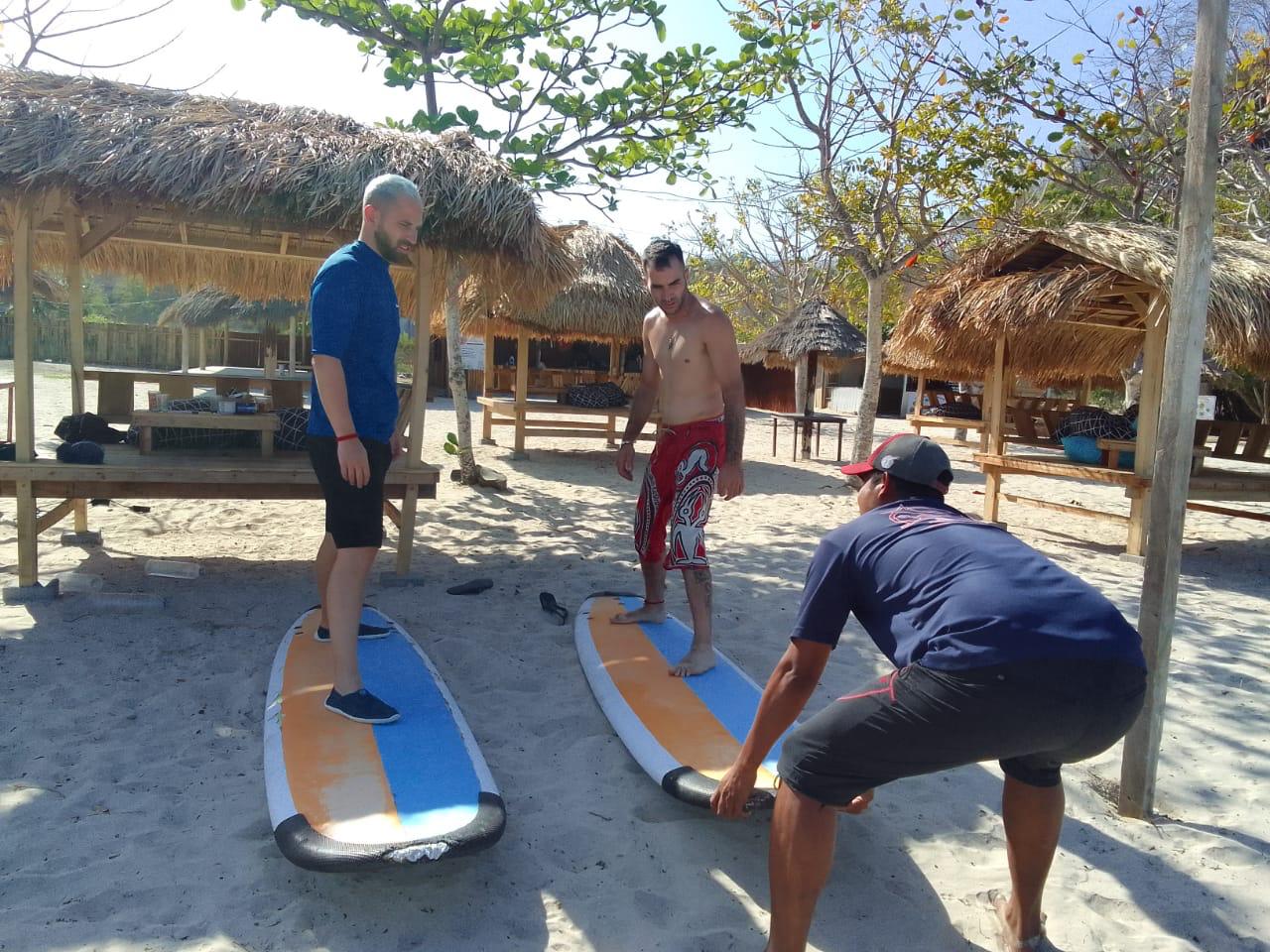 SUMBER PENGHASILAN: Irawan saat mengajarkan salah seorang tamu asing di teluk Ekas saat menyewa papan Surfing miliknya, Senin (30/6).