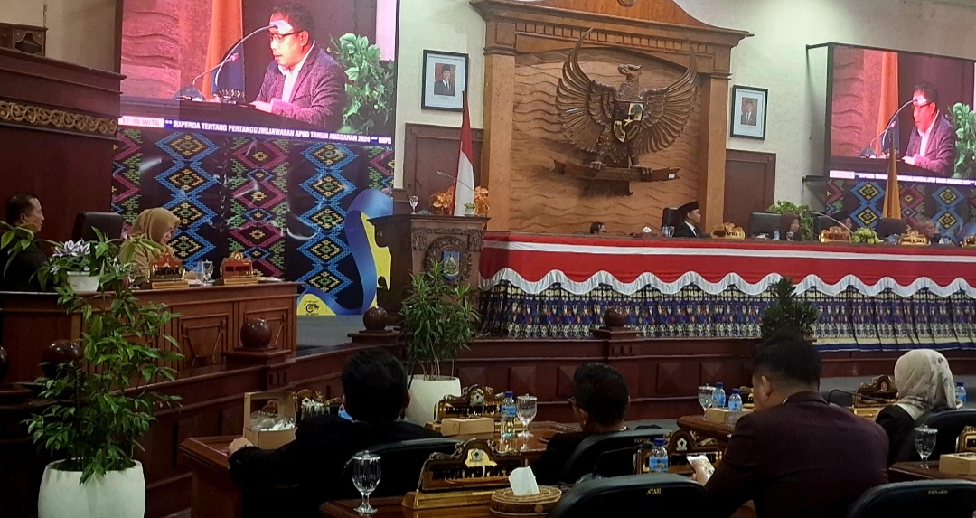 SAMPAIKAN REKOMENDASI: Juru Bicara Pansus DPRD NTB Muhammad Aminurlah membacakan persetujuan terkait Raperda Struktur Organisasi dan Tata Kelola (SOTK) dalam sidang paripurna, Senin (30/6).