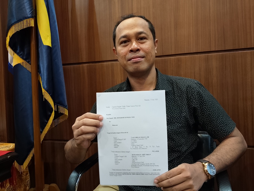 TUNJUKKAN BUKTI LAPORAN: Hendi Ronanto menunjukkan laporan dugaan tindak pidana laporan palsu dan pencemaran nama baik yang dilakukan pejabat Kanwil Kemenkum, Rabu (2/7).