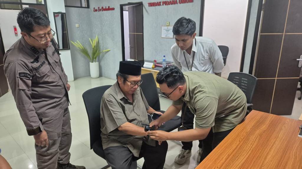 DIPASANGKAN APE: Tersangka kasus penipuan dan penggelapan Suhaili Fadhil Thohir dipasangkan APE setelah ditetapkan sebagai tahanan kota, Kamis (3/7).&nbsp;
