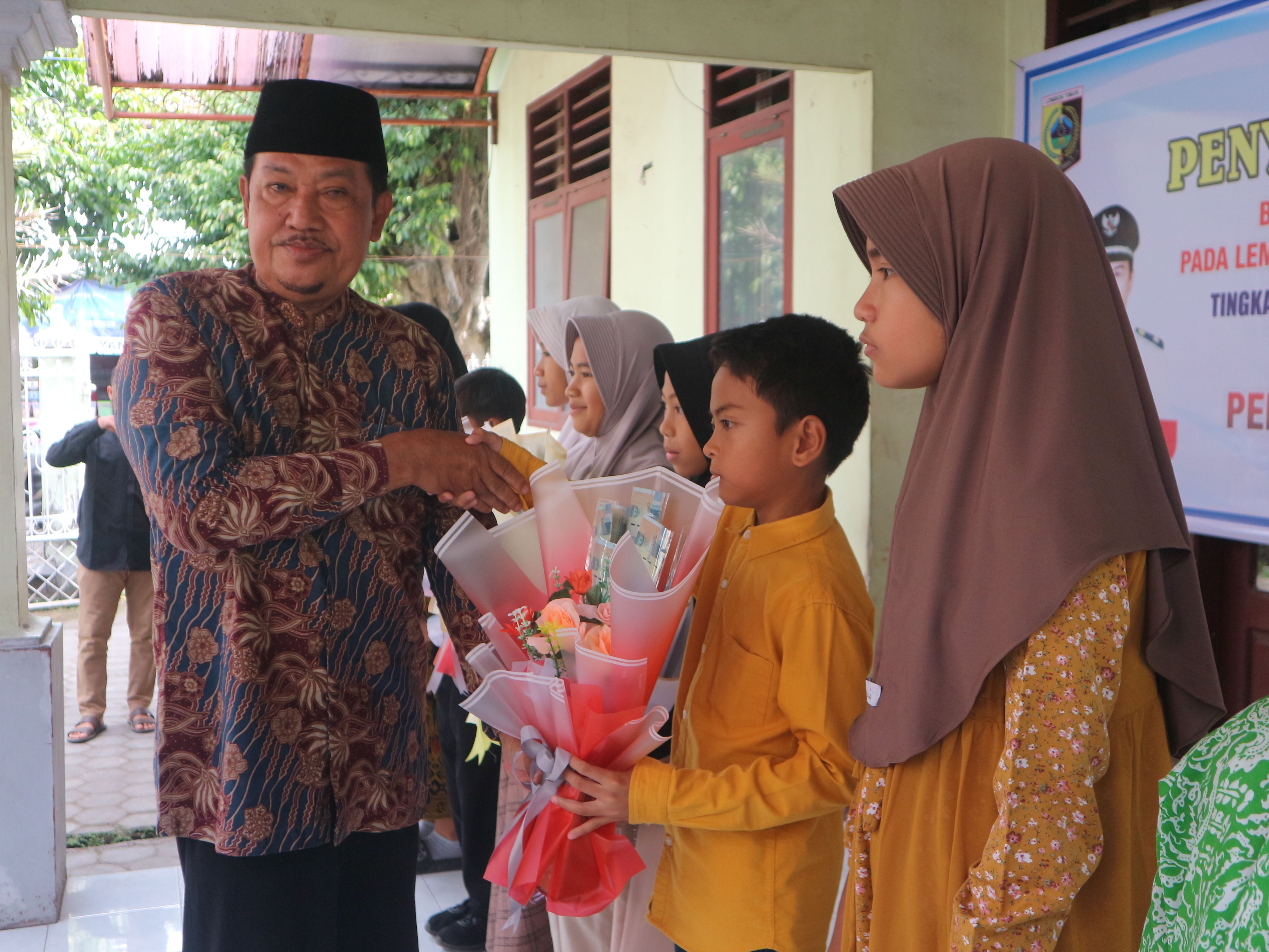 Kepala Desa (Kades) Suralaga, Kecamatan Suralaga saat menyerahkan beasiswa kepada siswa-siswi berprestasi se Desa Suralaga.