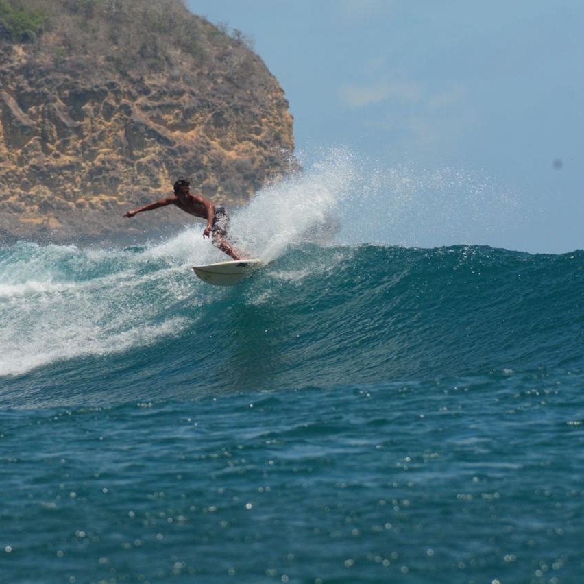 Seorang tamu asing sedang menikmati surfing di salah satu spot Surfing di teluk Ekas. (Kowor untuk Lombok Post)
