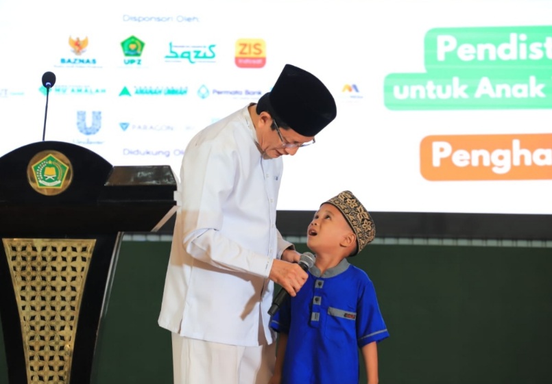 Menteri Agama  Nasaruddin Umar berbincang dengan salah satu anak yatim di acara pemberian bantuan di Jakarta, Jumat, 4 Juli 2025.