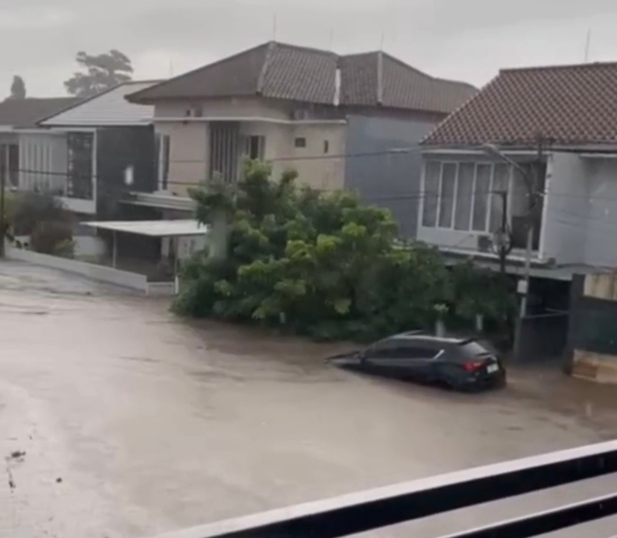 Sebuah mobil hanyut oleh arus deras banjir di sebuah perumahan kawasan Cakranegara.