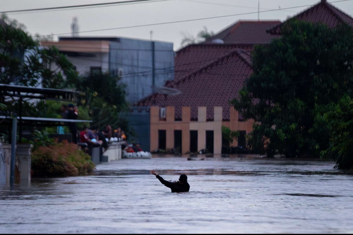 Seorang warga tengah menyelamatkan diri dari derasnya air di lokasi banjir BTN Riverside, Cakranegara.