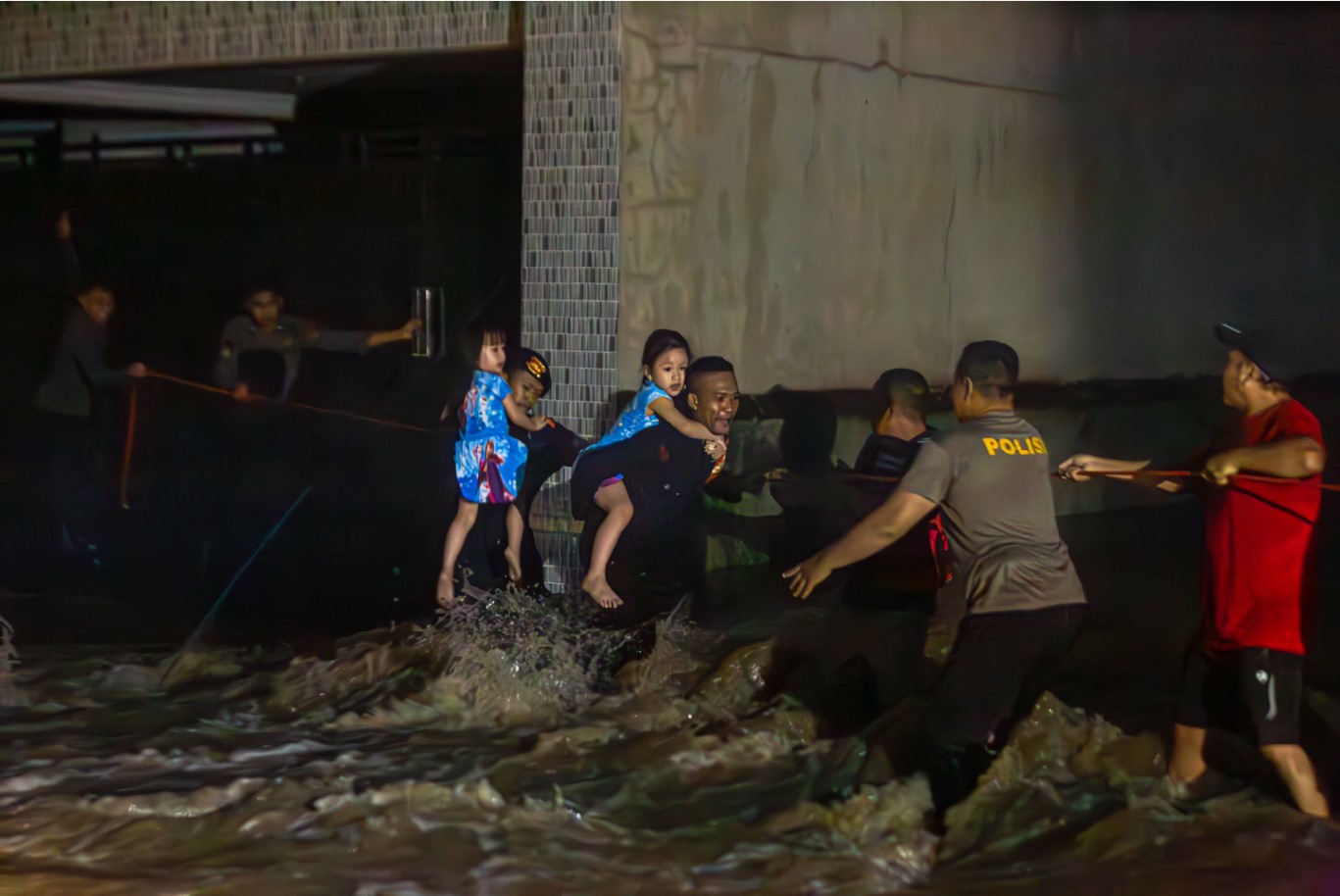 EVAKUASI: Tim gabungan menggunakan tali agar tidak terseret arus saat melakukan evakuasi korban banjir di Perumahan Riverside, Selagalas, Kota Mataram, Minggu (6/7).&nbsp;