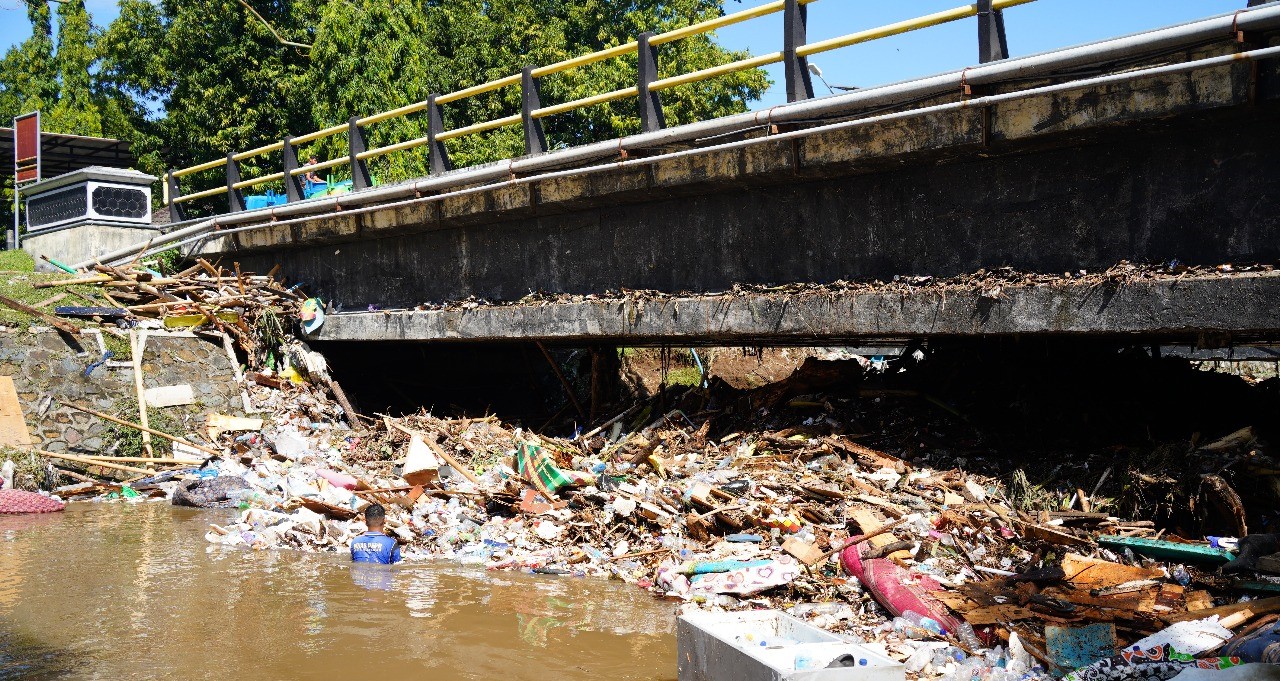 Tumpukan sampah di jembatan menjadi penyebab banjir di Lingkungan Unram, Minggu lalu (6/7).