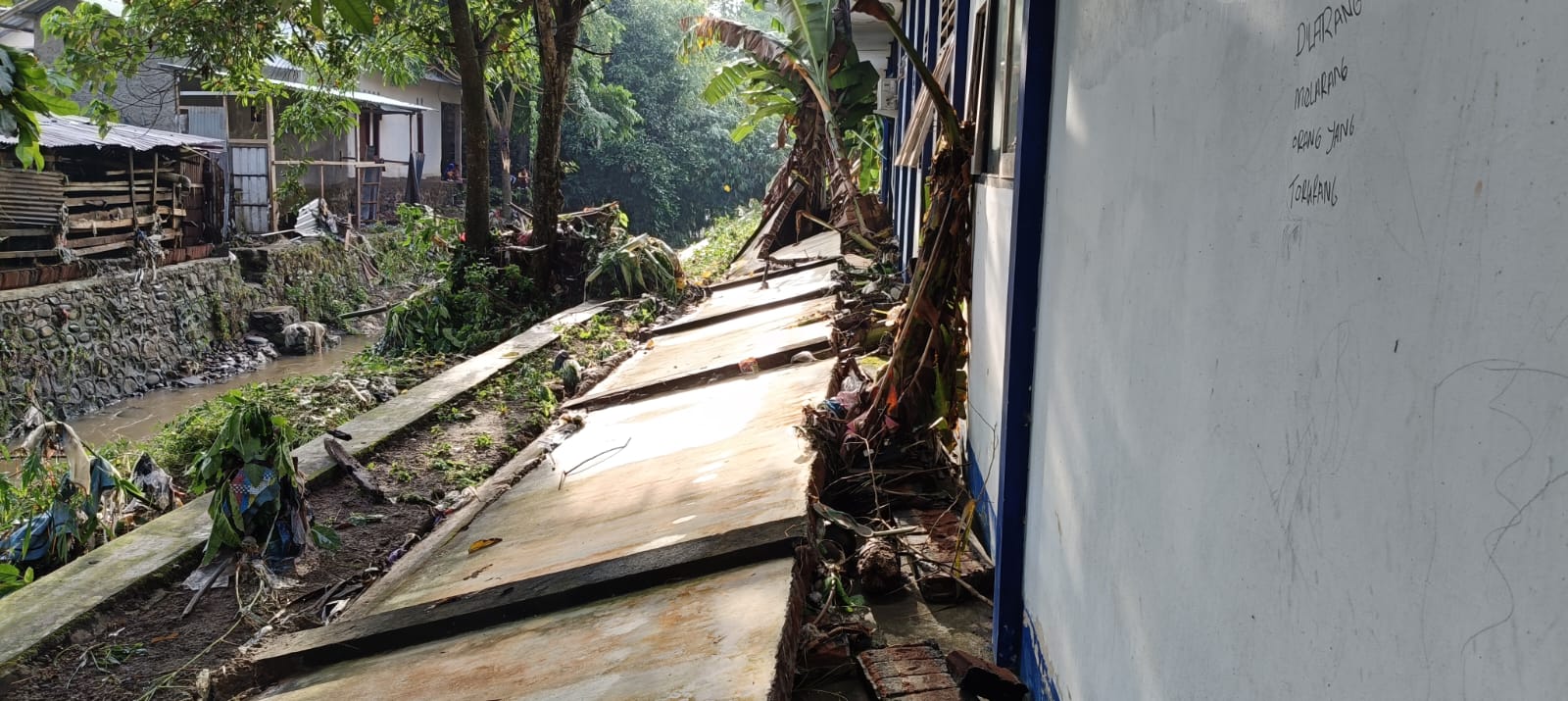 Tembok pembatas SMPN 22 Mataram roboh karena luapan air sungai yang ada di utara sekolah, Minggu lalu (6/7).