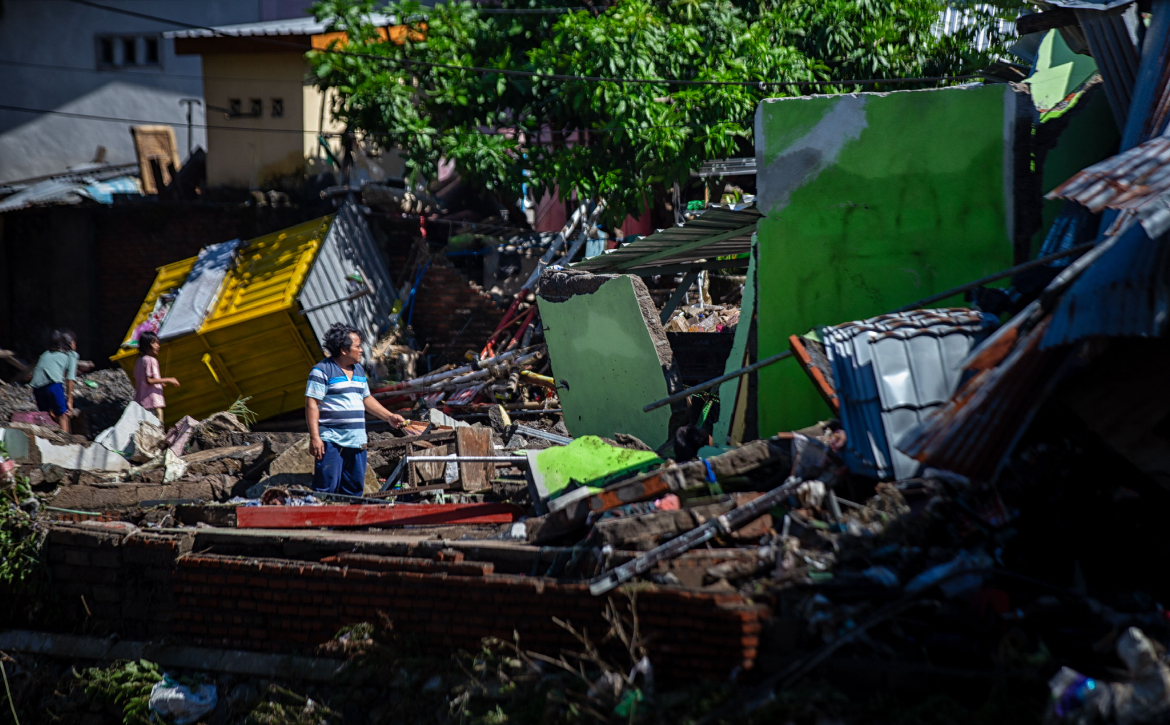 Seorang sarga berdiri ditengah puing-puing rumah terdampak banjir mataram.