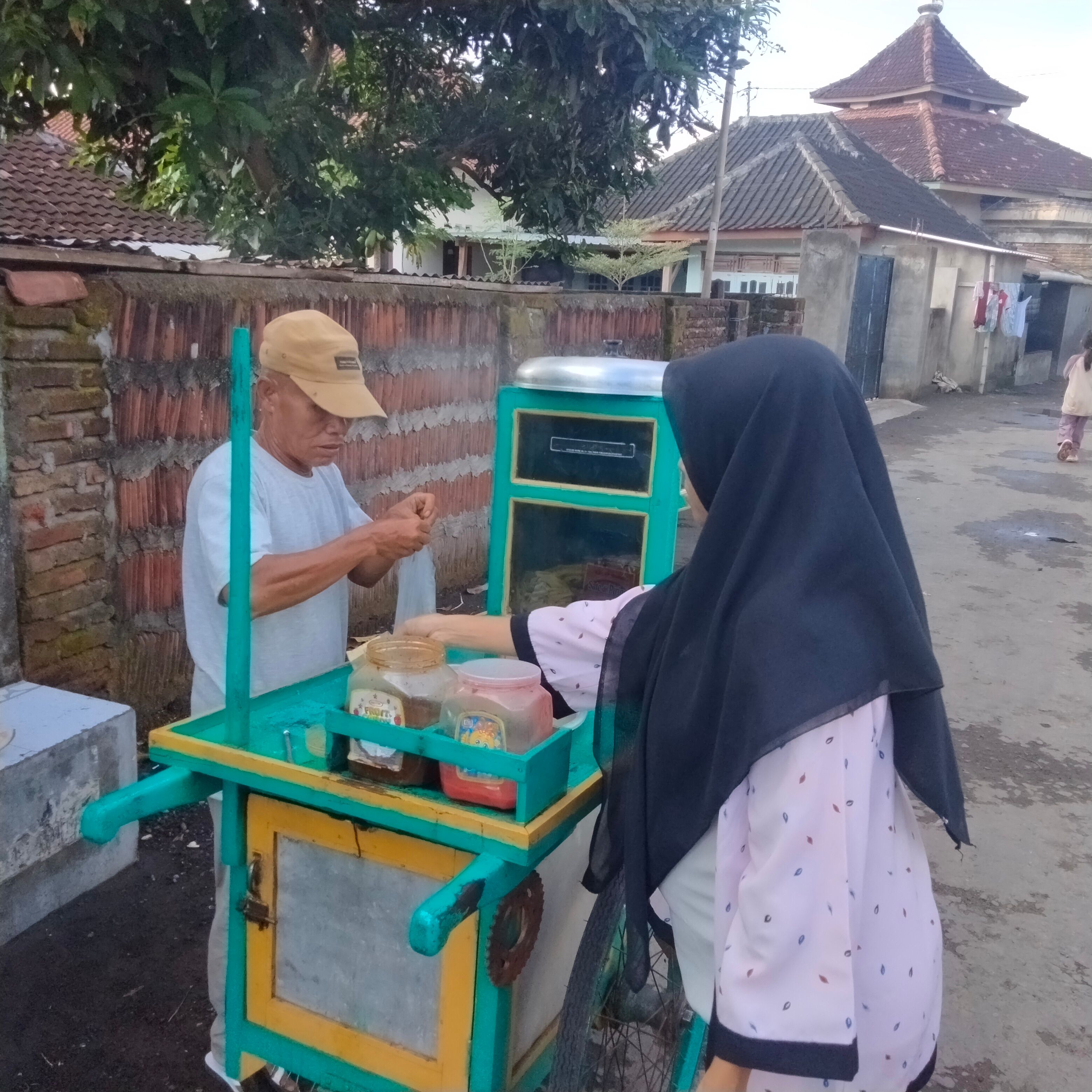 Seorang ibu muda sedang membeli cilok milik  Nasar atau cilok aca, yang cukup terkenal di Kecamatan  Sakra, Senin (7/7).