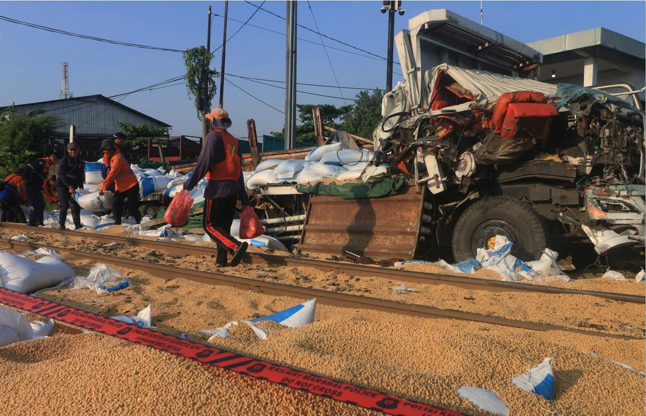 RINGSEK: Tampak truk pengangkut kedelai ringsek setelah ditabrak KA Harina 96 di perlintasan kereta api Kaligawe, Kota Semarang, Selasa (8/7).