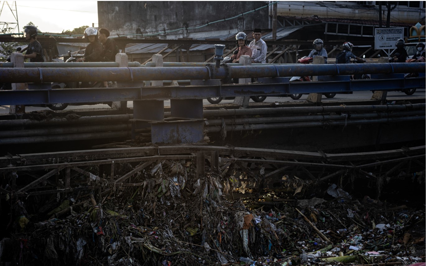 PENUH SAMPAH: Seorang warga melihat sampah yang menumpuk di bawah jembatan Lingkungan Kekalik, Kota Mataram, Selasa (8/7).