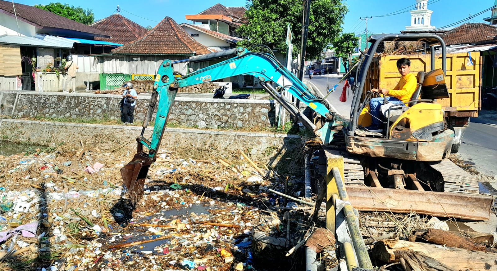 TERSUMBAT SAMPAH: Dinas PUTR Lobar menerjunkan alat berat untuk mengangkat sampah yang memadati sungai di Keluarahan Dasan Geres.