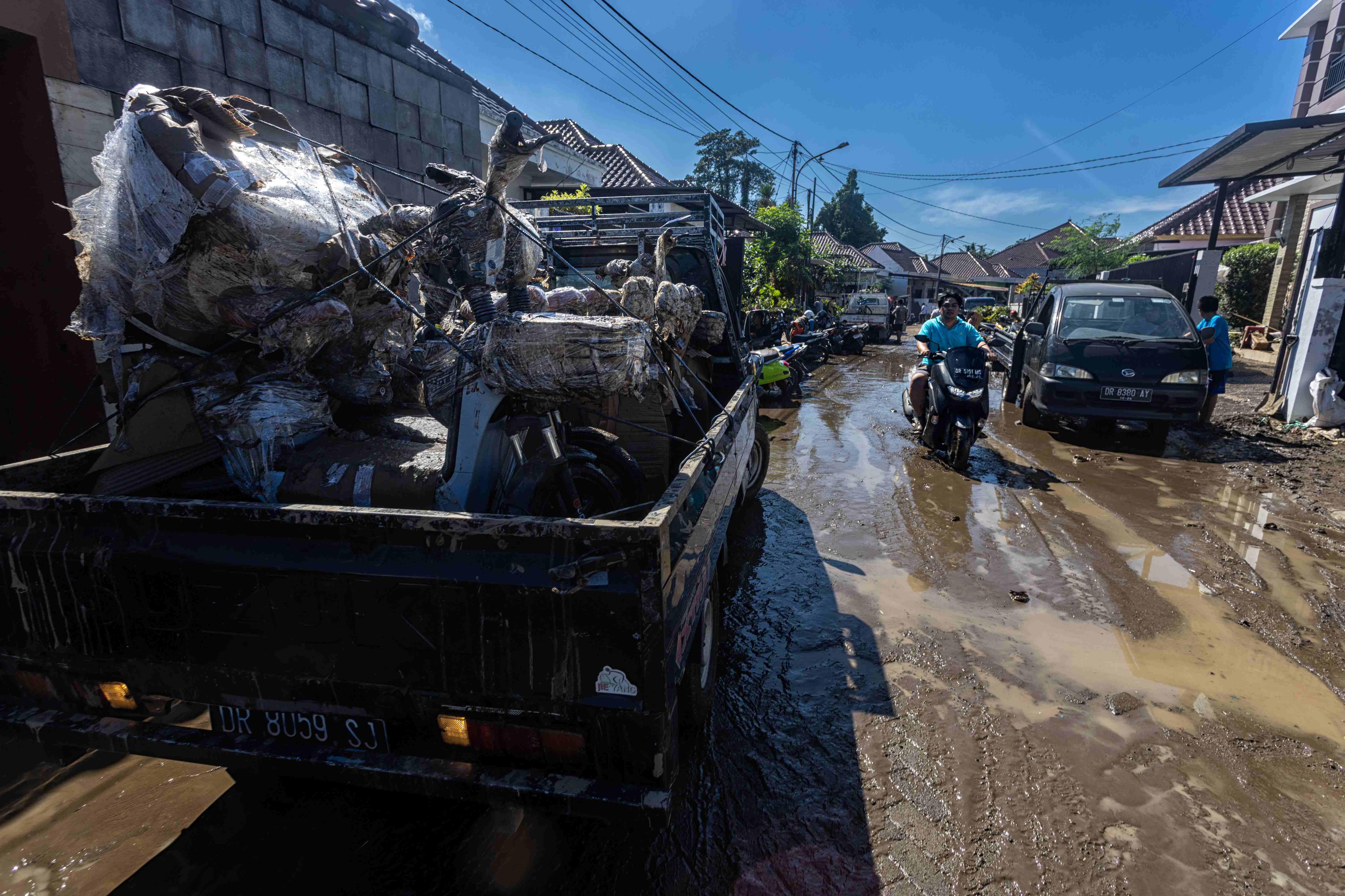 BEBERES: Selepas banjir yang melanda Mataram dan Lombok Barat, Minggu (6/7), warga terdampak mulai melakukan kegiatan bersih-bersih.