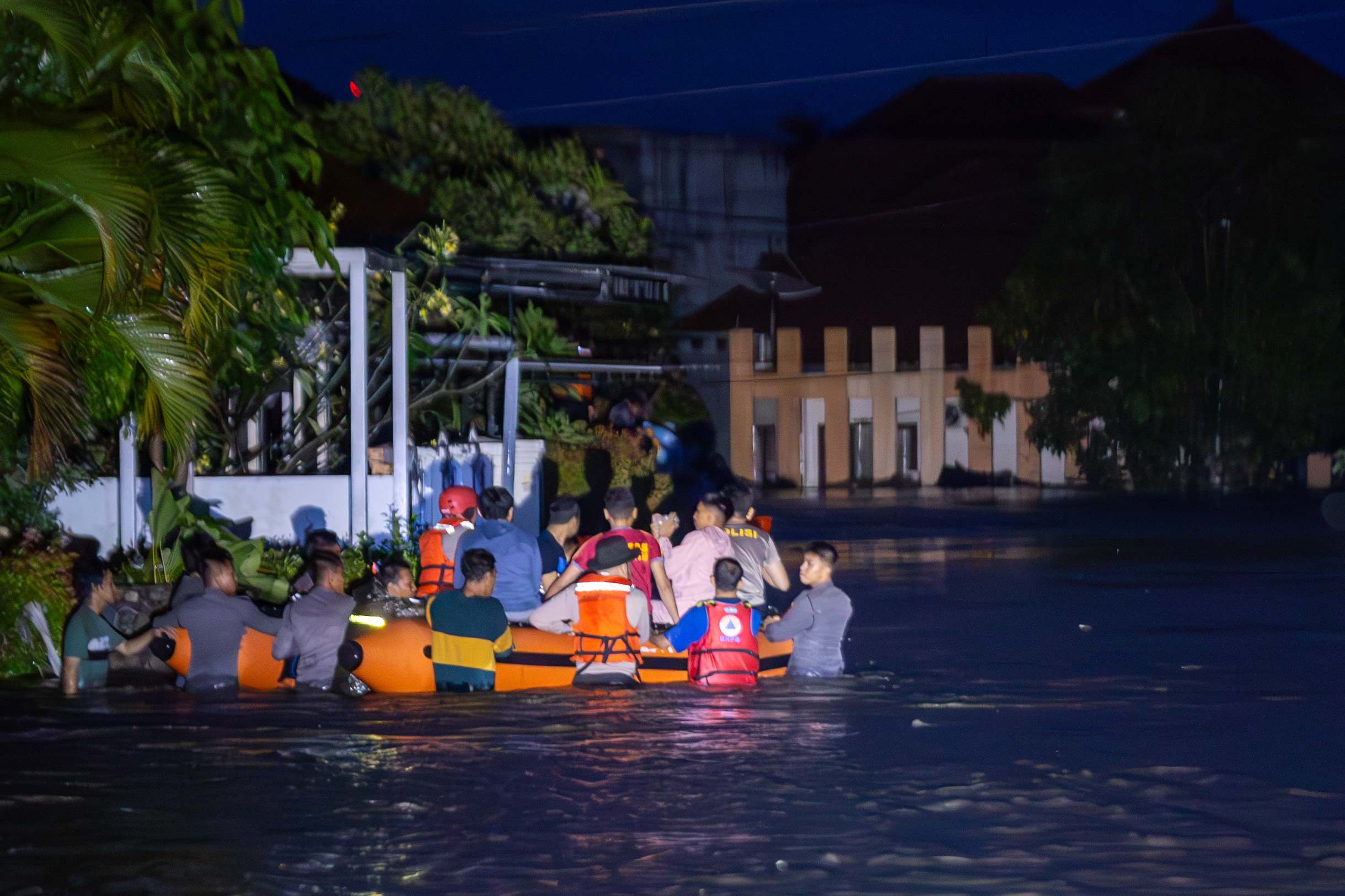 KERJA SAMA: Proses evakuasi warga yang terdampak banjir di Mataram, Minggu malam (6/7).