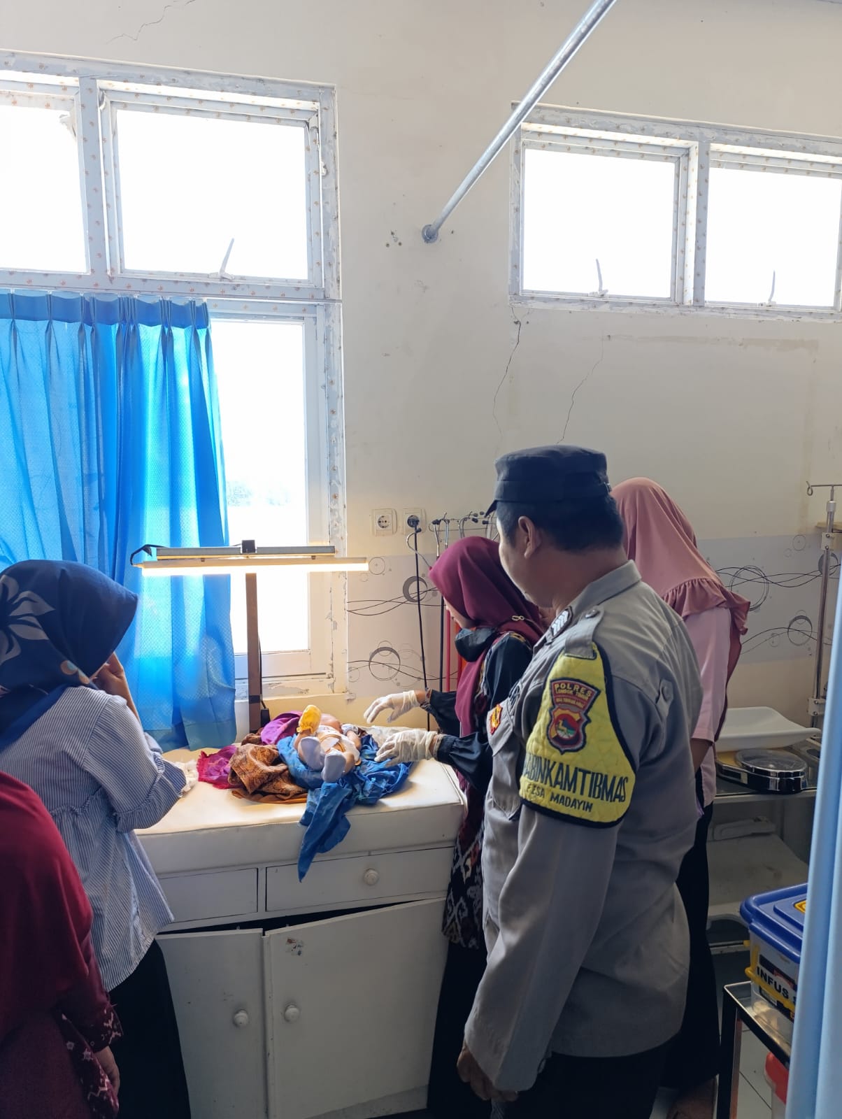 Polisi saat mengecek kondisi bayi yang ditemukan di Pinggir jalan raya Belanting saat menjalani perawatan di Puskesmas Belanting. (Humas Polres Lotim).