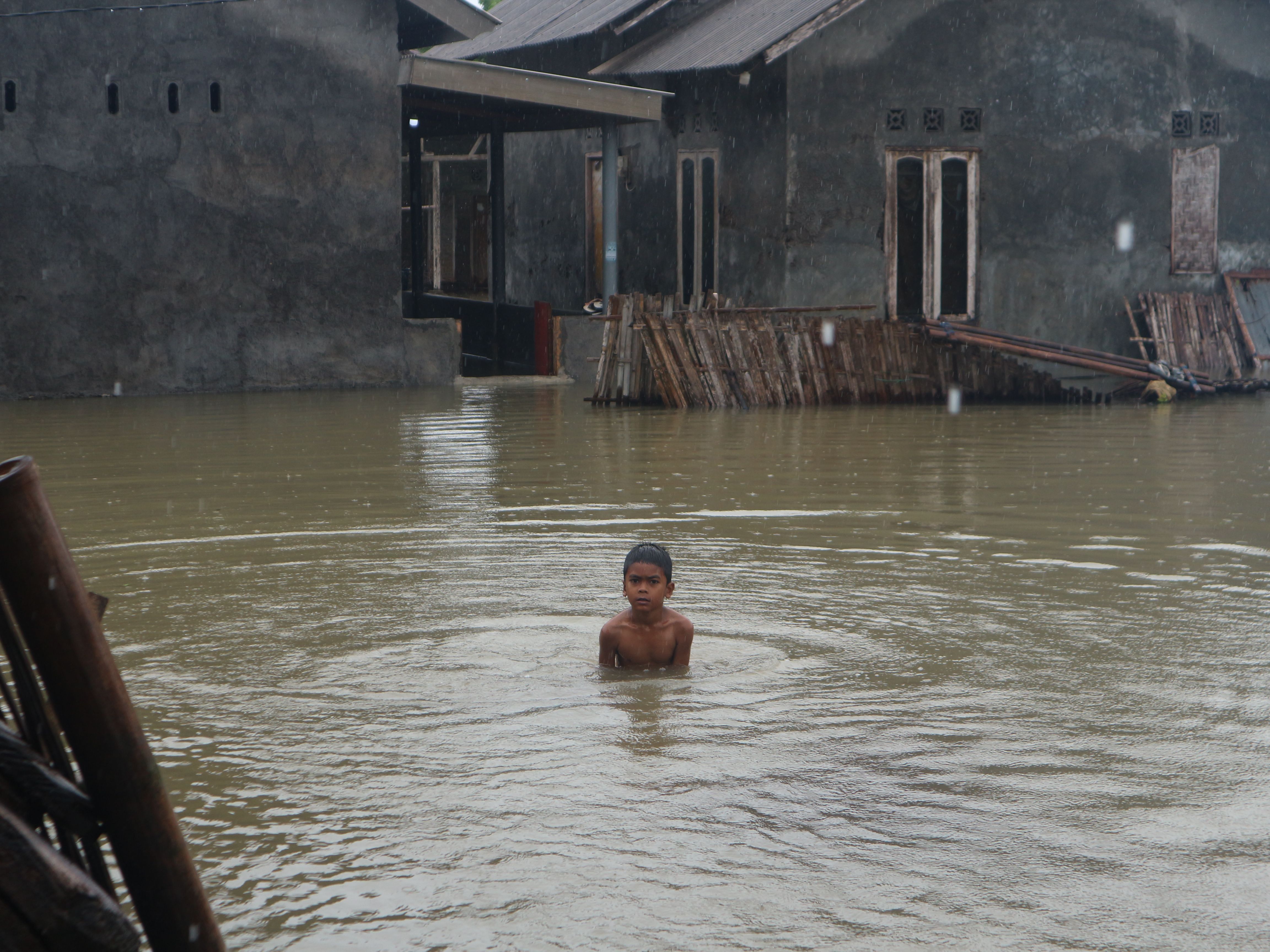 Seorang anak tengah mandi di tengah banjir yang melanda salah satu desa di Kecamatan Keruak beberapa waktu lalu. (Dok: Lombok Post)