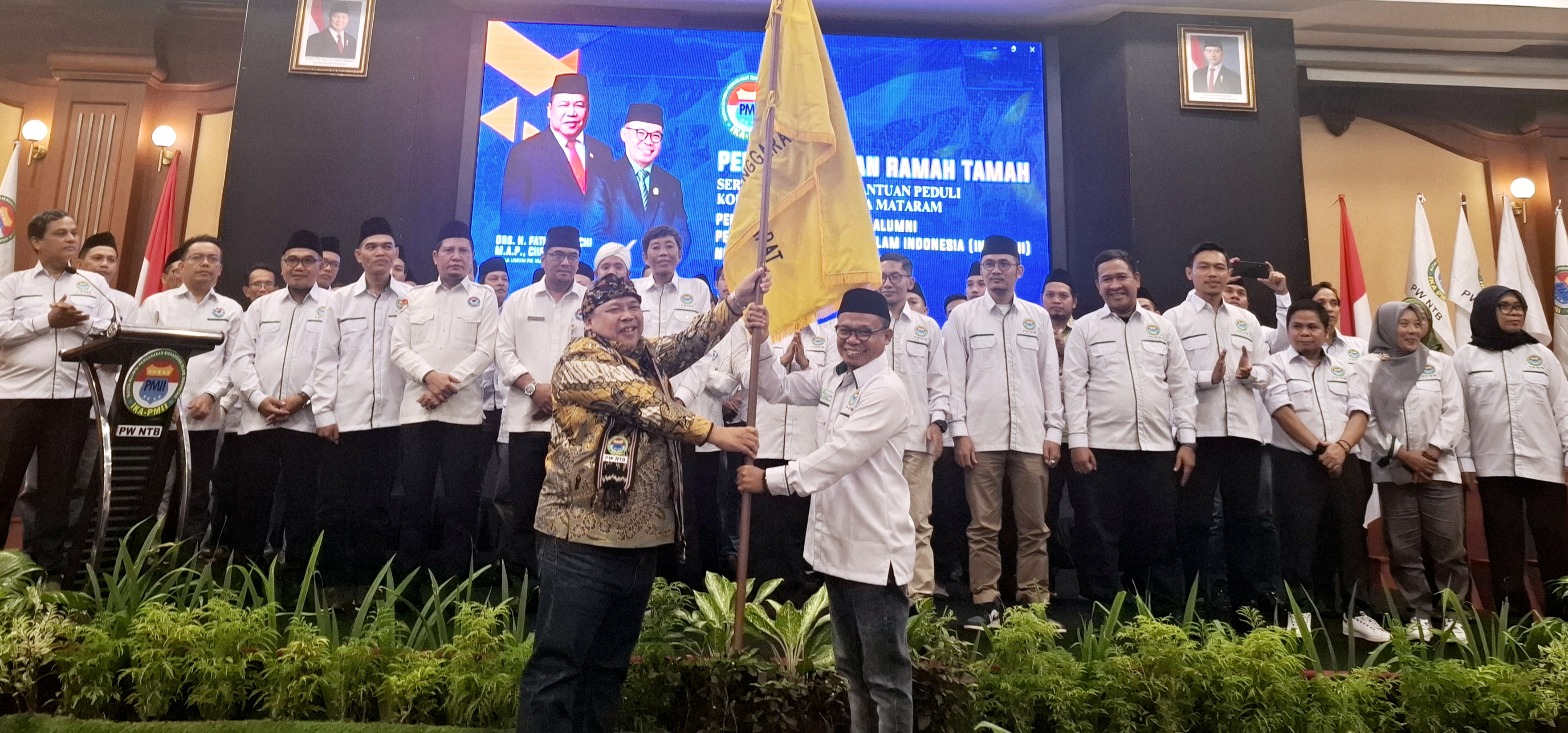SIAP BERSINERGI: Ketua Umum Pengurus Besar (PB) IKA PMII Fathan Subchi (kiri) menyerahkan bendera pataka IKA PMII kepada Ketua Umum IKA PMII NTB Periode 2025-2030 Akhdiansyah (kanan), Kamis (10/7).