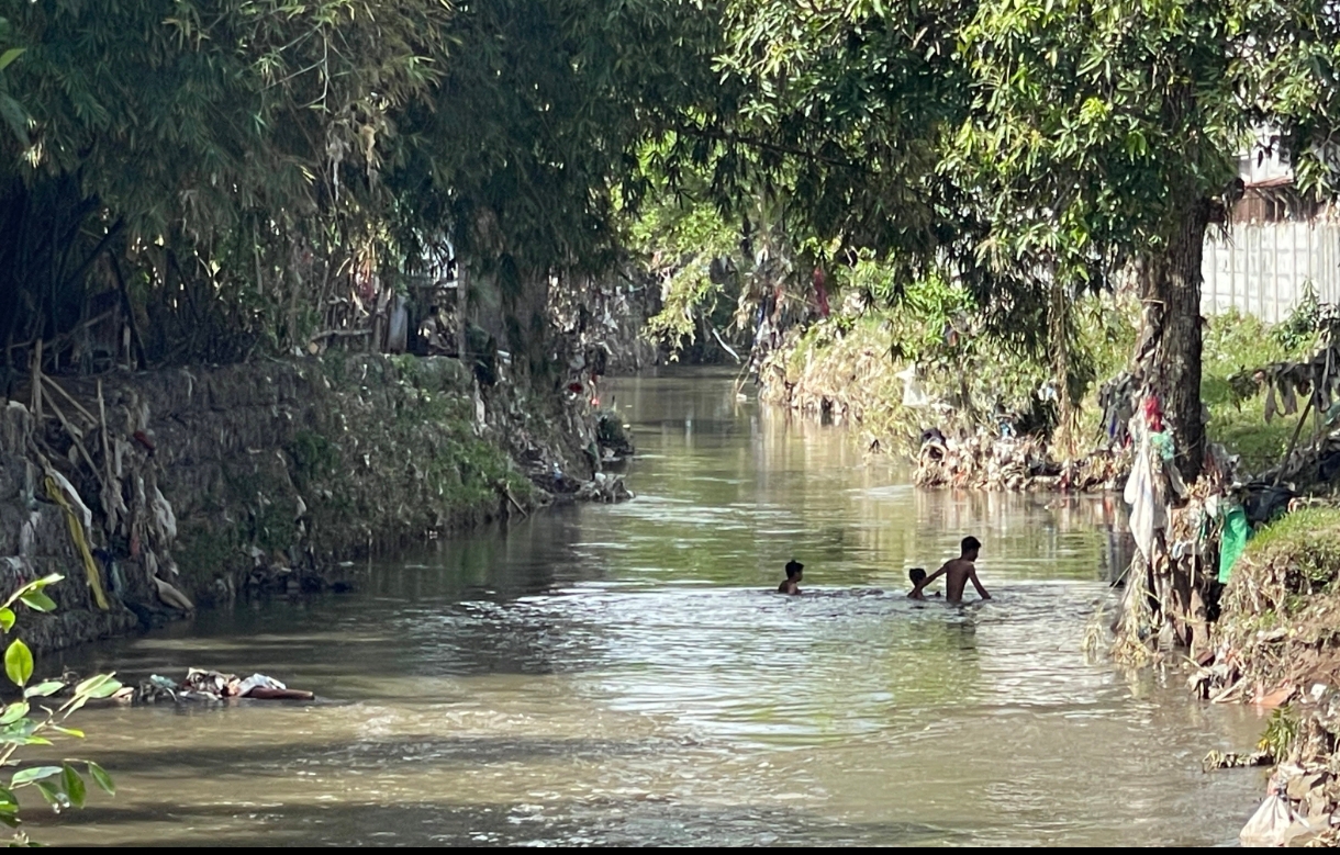 Tiga orang warga tengah berendam di sungai Ancar, Kebon Duren, Selagalas, Kota Mataram.