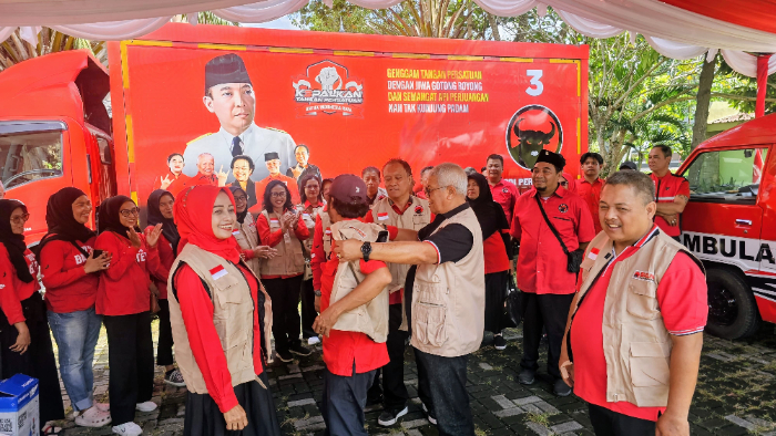 Ketua DPD PDI Perjuangan NTB H Rachmat Hidayat memasangkan rompi kepada BAGUNA DPC PDIP Kota Mataram,  Ahad (13/7/2025).
