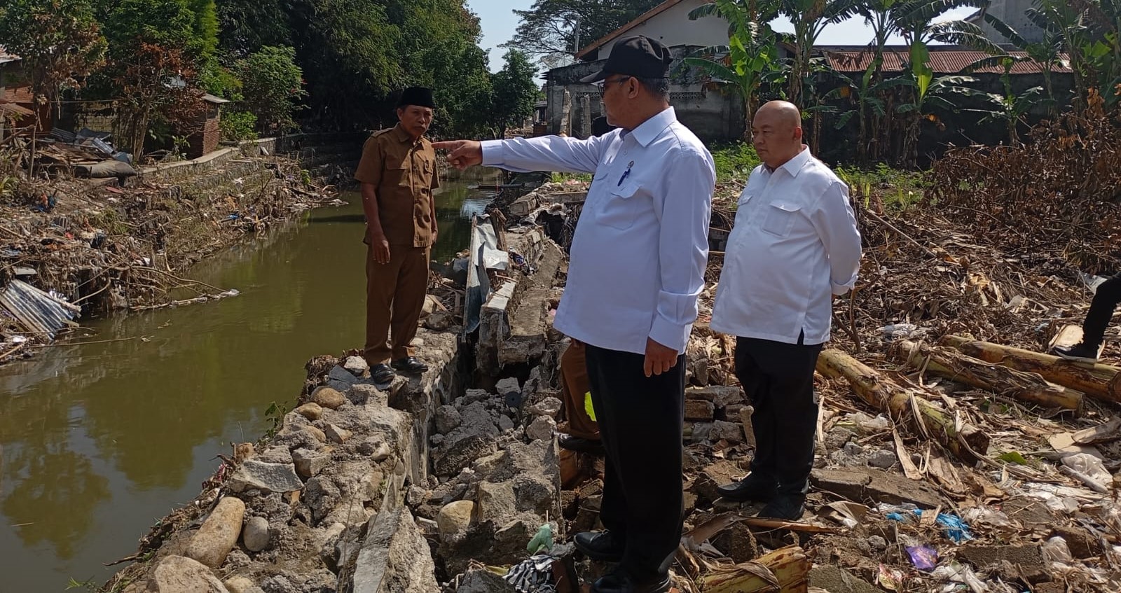 Mendikdasmen Abdul Mu&rsquo;ti (pakai topi) melihat tembok pembatas SMPN 16 Mataram yang roboh akibat banjir, Senin (14/7).