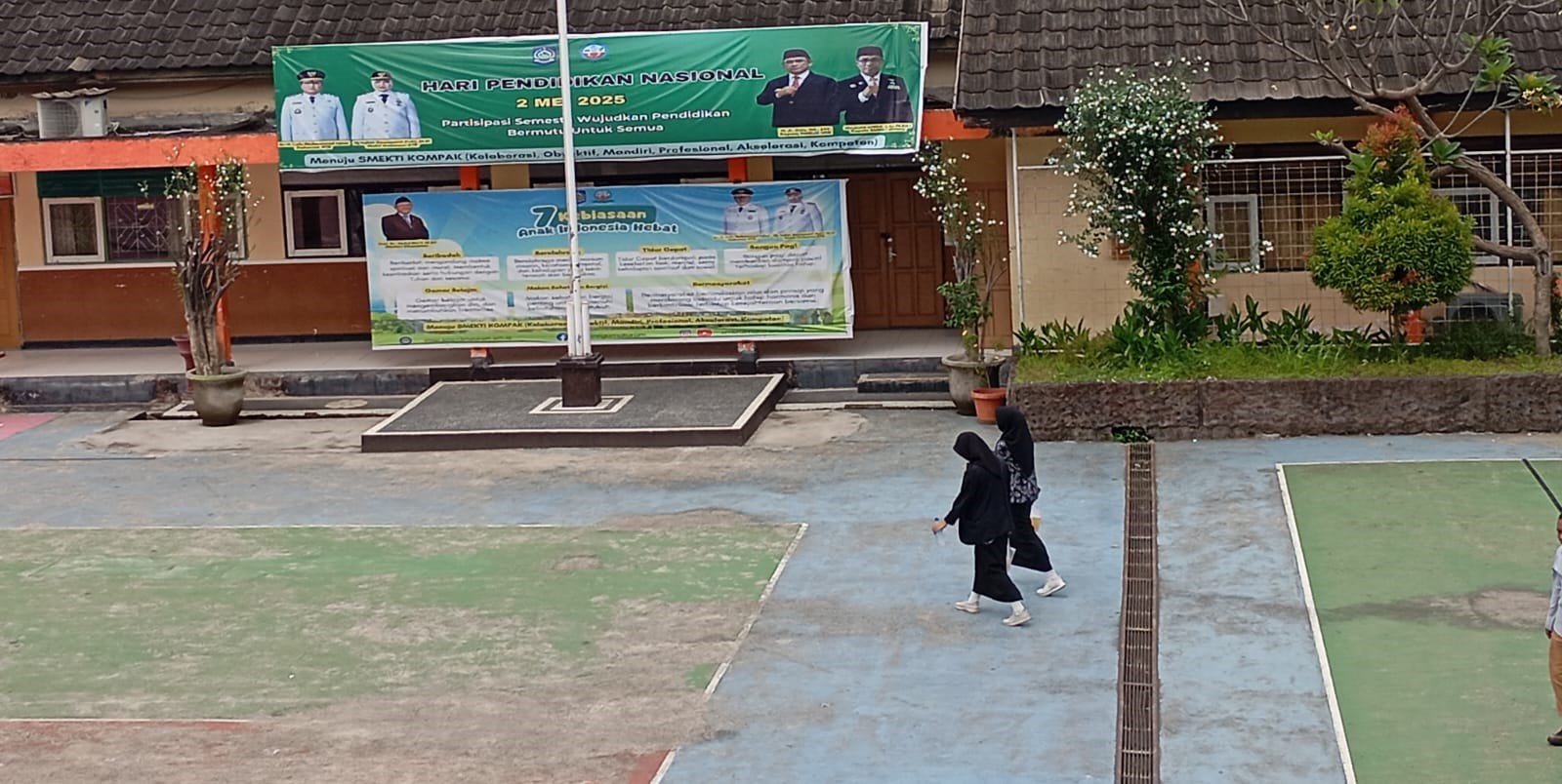 Dua orang siswa SMK negeri di Kota Mataram berjalan di lapangan sekolah.