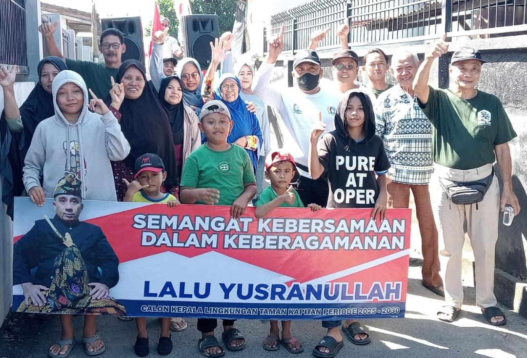 Tampak warga memegang spanduk yang bertuliskan "Semagat Kebersamaan Dalam Keberagaman Bersama Lalu Yusranullah Calon Kepala Lingkungan Taman Kapitan Periode 2025-2030", lengkap dengan fotonya.