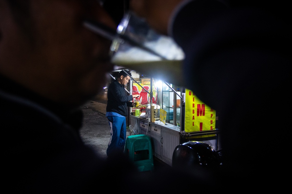 PELANGGAN SETIA: Seorang pria meminum jamu di kedai jamu milik Tisam di sebelah barat pasar Kebon Roek, Ampenan, Kota Mataram, Kamis (17/7).
