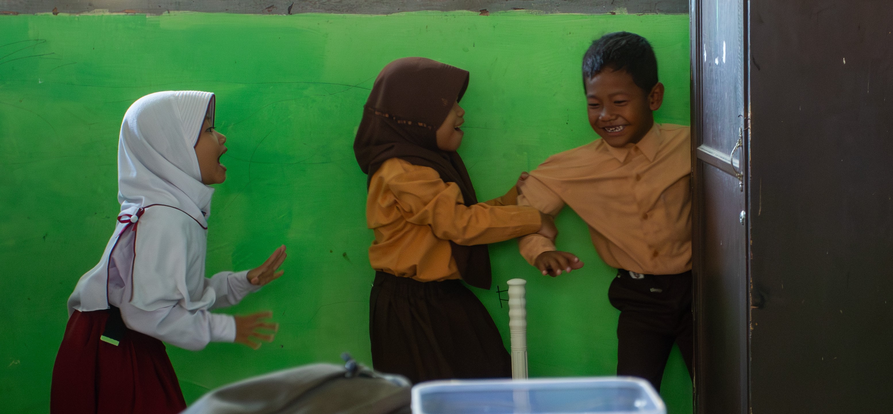 Tiga murid SD di Kota Mataram asyik bermain tanpa ada perundungan.