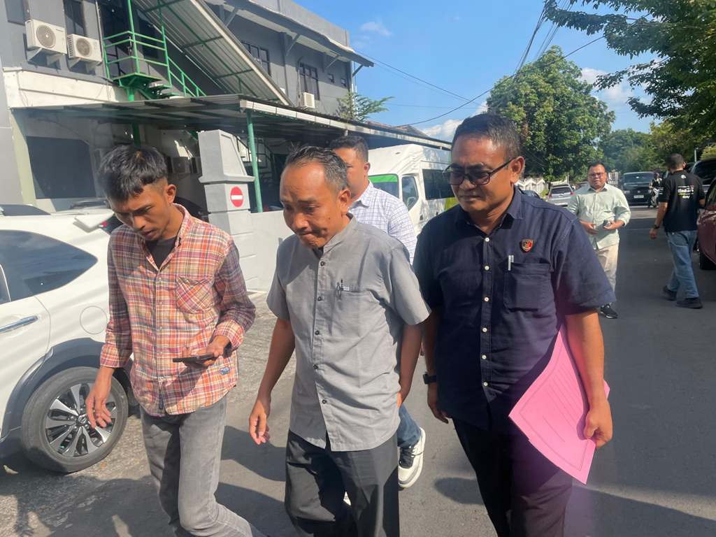DITAHAN: Tersangka korupsi pengadaan masker M Haryadi Wahyudin (tengah) dikawal penyidik sambil memberikan keterangan kepada wartawan, Selasa (22/7).&nbsp;