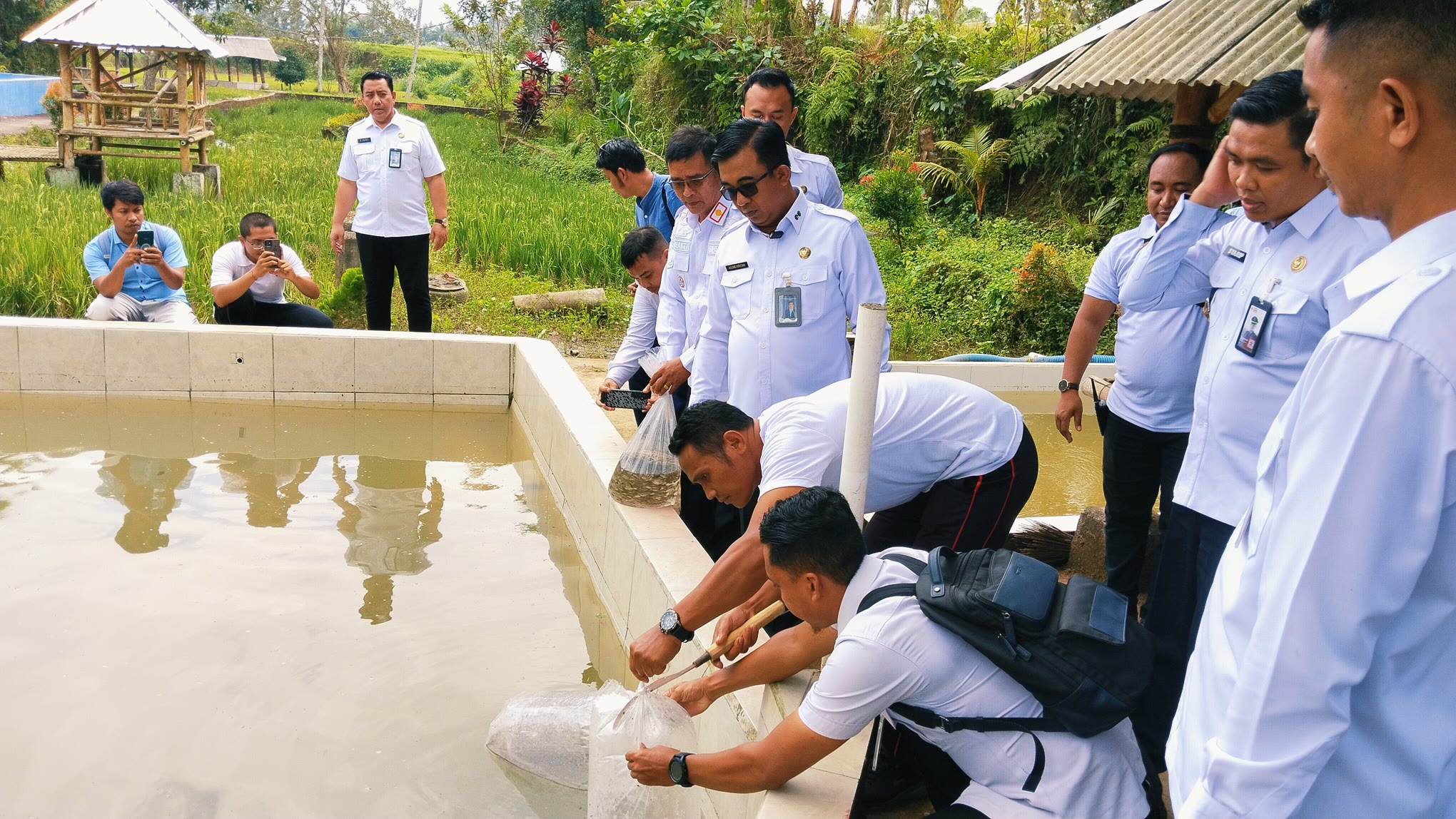BINA NARAPIDANA: Kakanwil Ditjen PAS NTB A. Agung Gde Krisna (kaca mata hitam) melepas ribuan benih ikan di salah satu kolam di Lapas Terbuka Kelas IIB Lombok Tengah, Rabu (23/7).