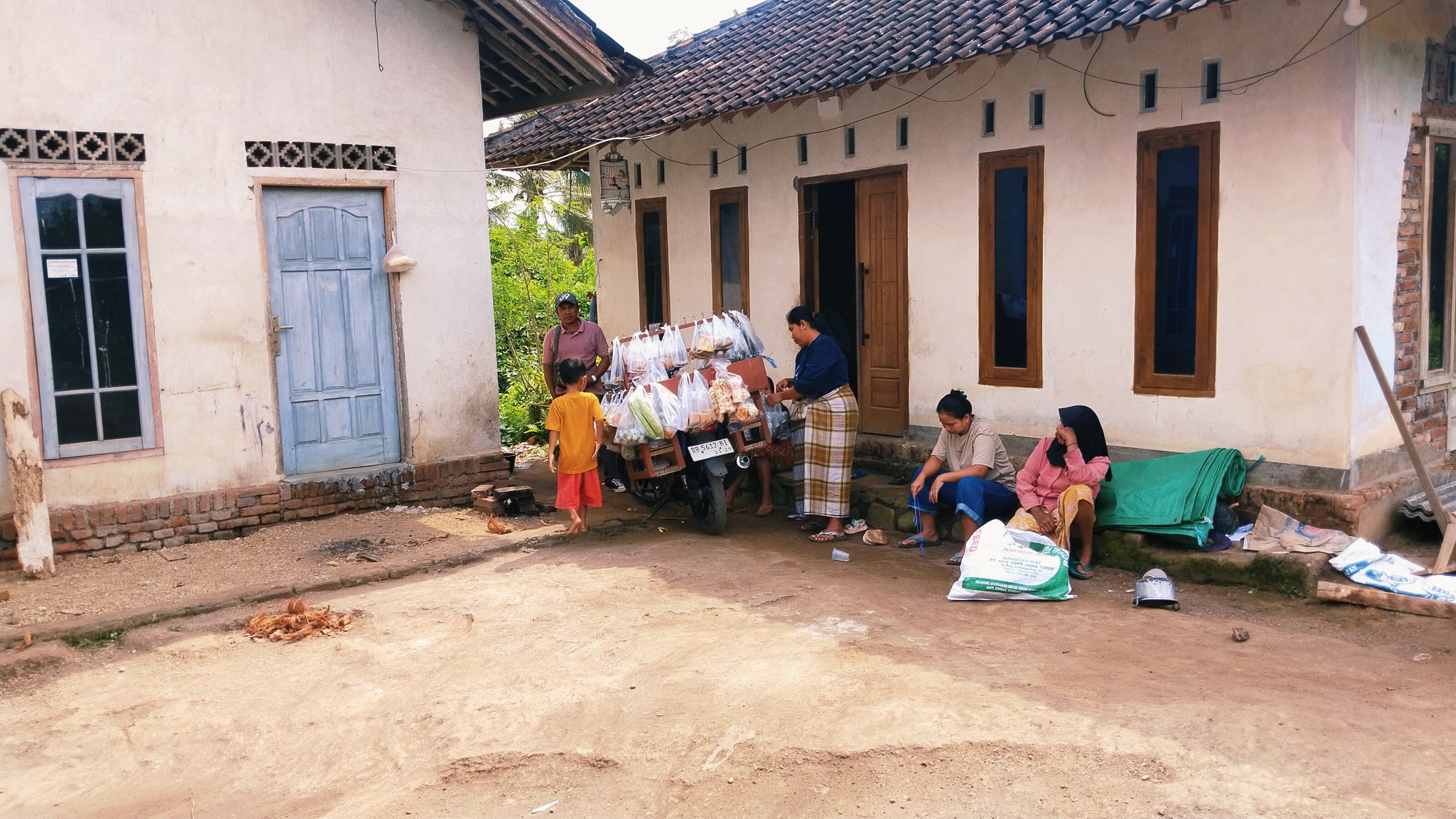 WIN-WIN SOLUSI: Sejumlah ibu-ibu sedang berbelanja pada pedagang sayur yang berjualan ke kediaman mereka di Desa Taman Indah, Pringgarata, Lombok Tengah, Rabu (23/7).