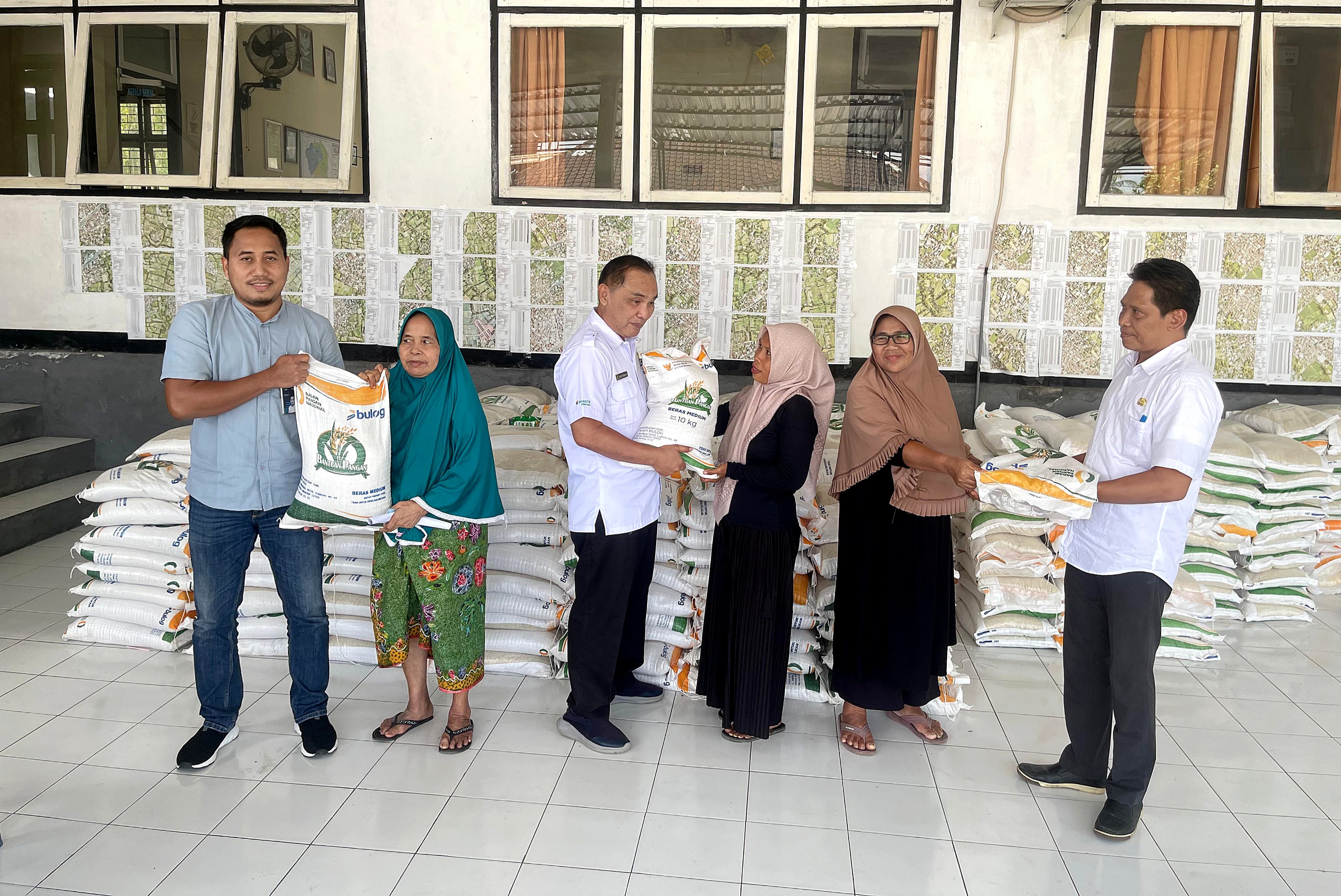 Kepala Bulog Lotim saat menyerahkan bantuan pangan kepada seorang penerima di Kecamatan Labuhan Haji.