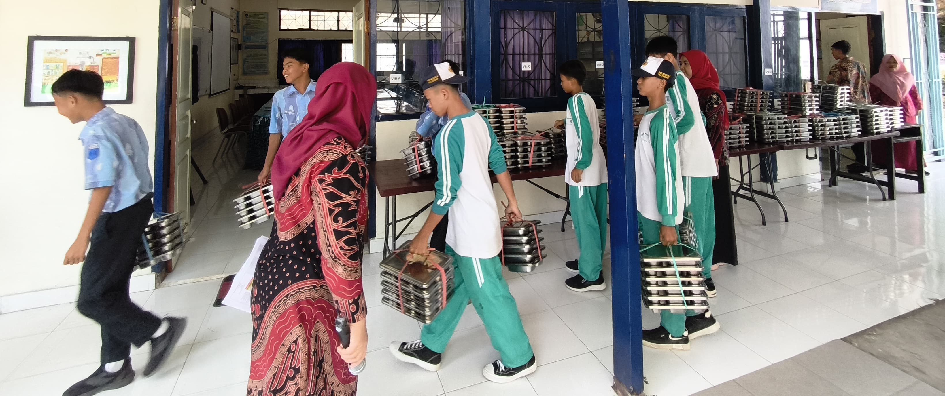 Perwakilan siswa SMPN 8 Mataram saat mengambil paket makanan program MBG.