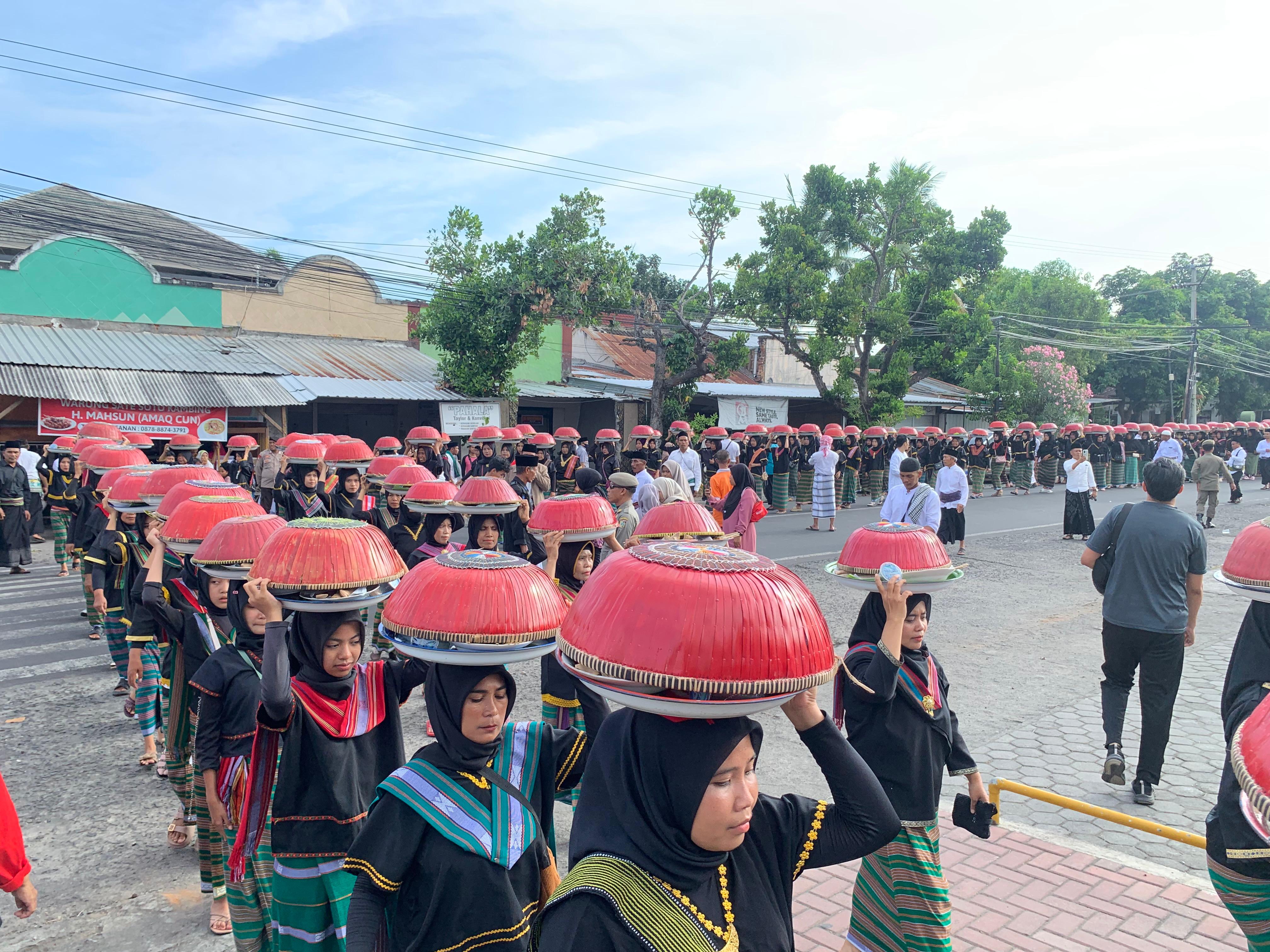 Sejumlah ibu-ibu asal Desa Pengadangan saat melakukan pawai seribu dulang pada acara Festival Muharam.