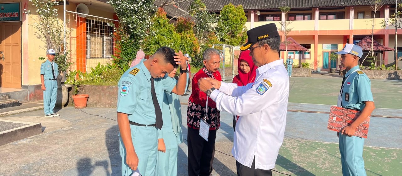 Kepala SMKN 3 Mataram Sulman Haris mengalungkan name tag sebagai tanda resmi dimulainya MPLS Ramah.
