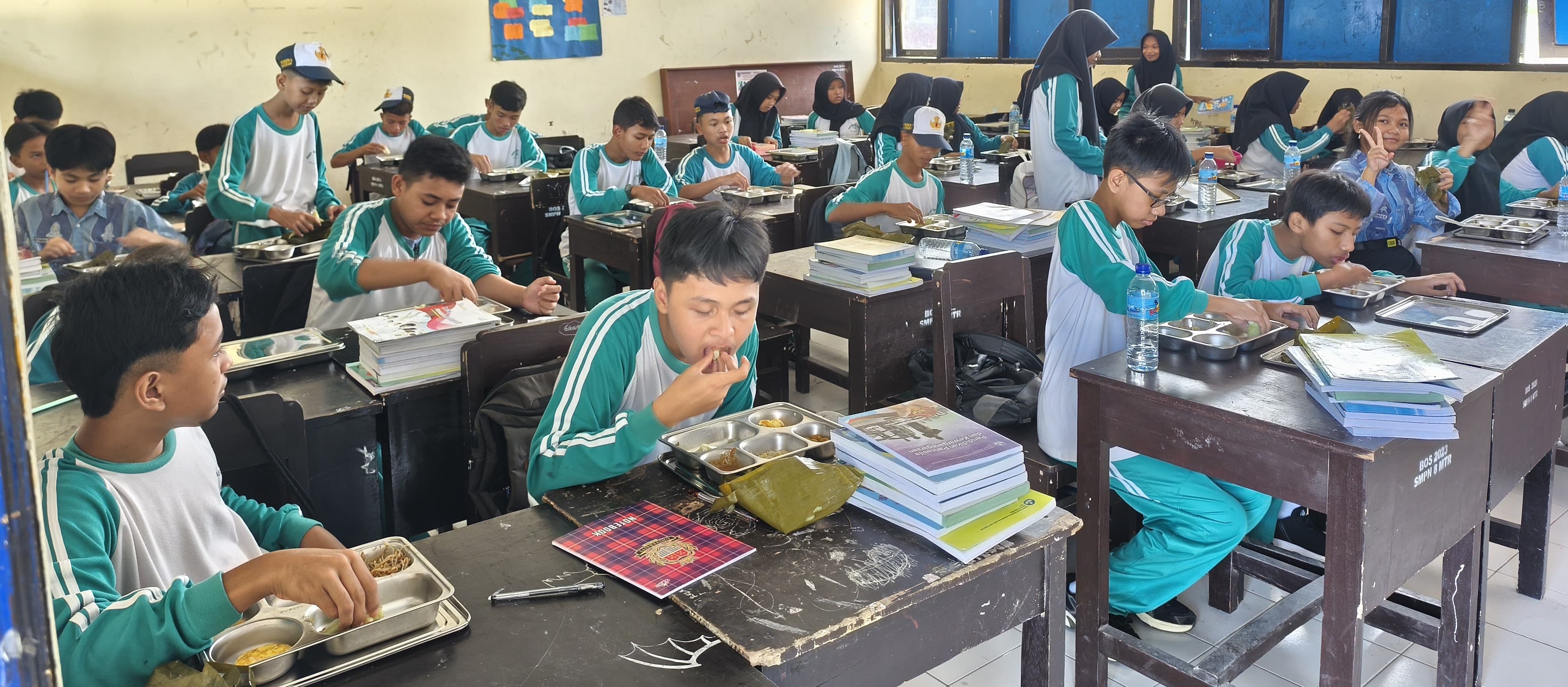 Siswa SMPN 8 Mataram menyantap makanan pada program MBG di sekolah.