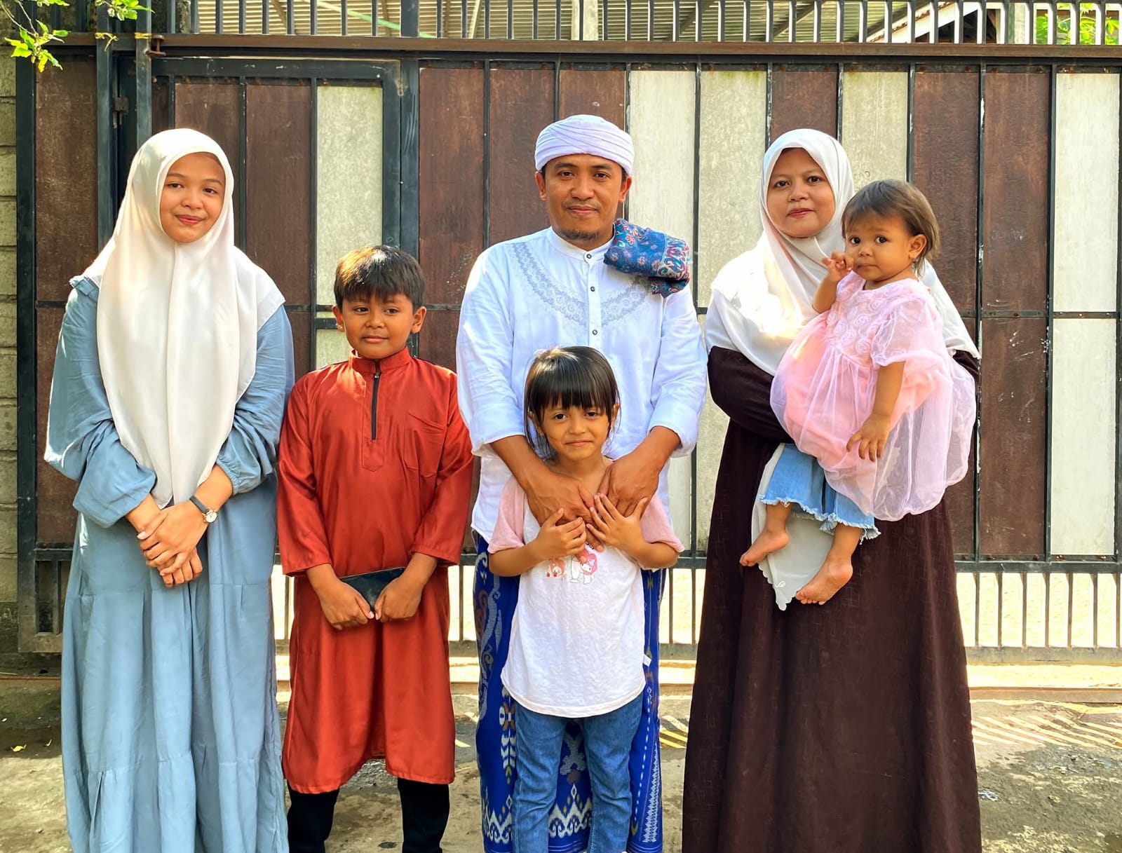 KABAHAGIAAN HAKIKI: Tuan Guru Supardi Ramli Reme bersama anak-anak dan istri berfoto di depan kediamannya, beberapa waktu lalu.